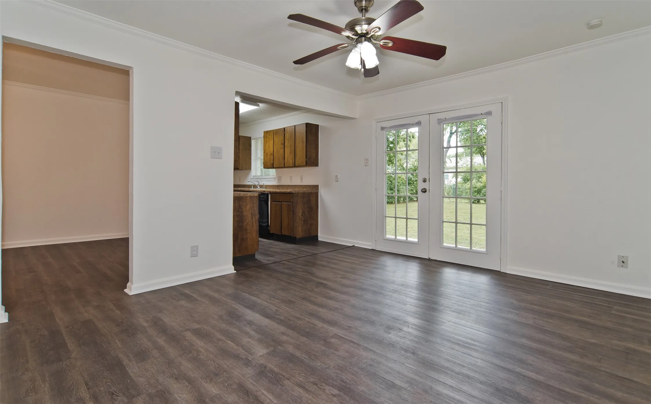 Dining room wood-finish flooring, white walls, and crown molding