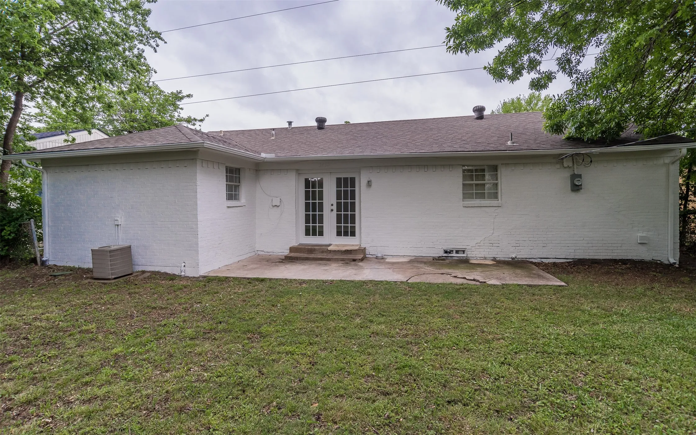 Rear exterior featuring a concrete patio and a manicured lawn