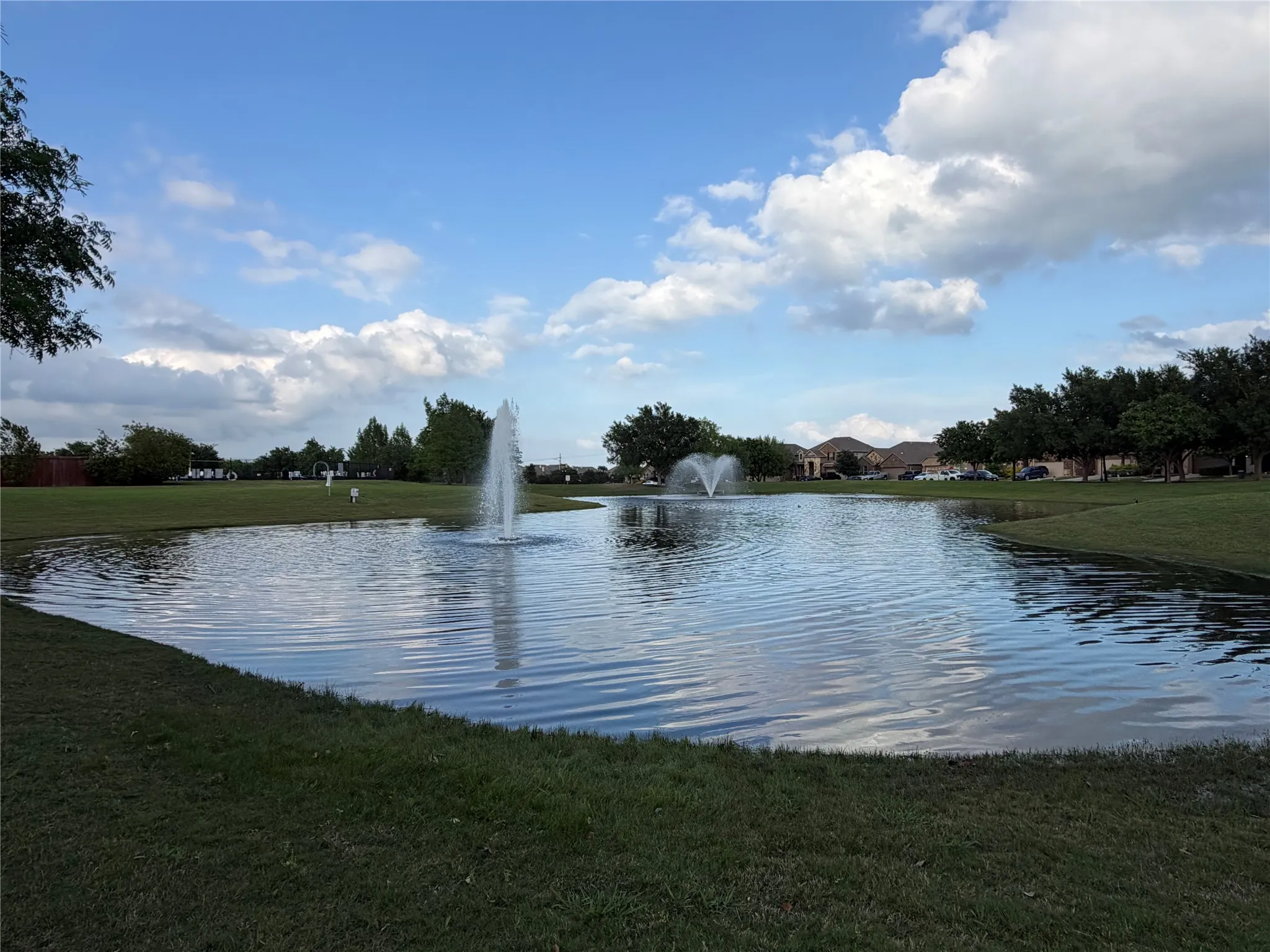 Green Space with Two Fountains Behind the Club House and Pool
