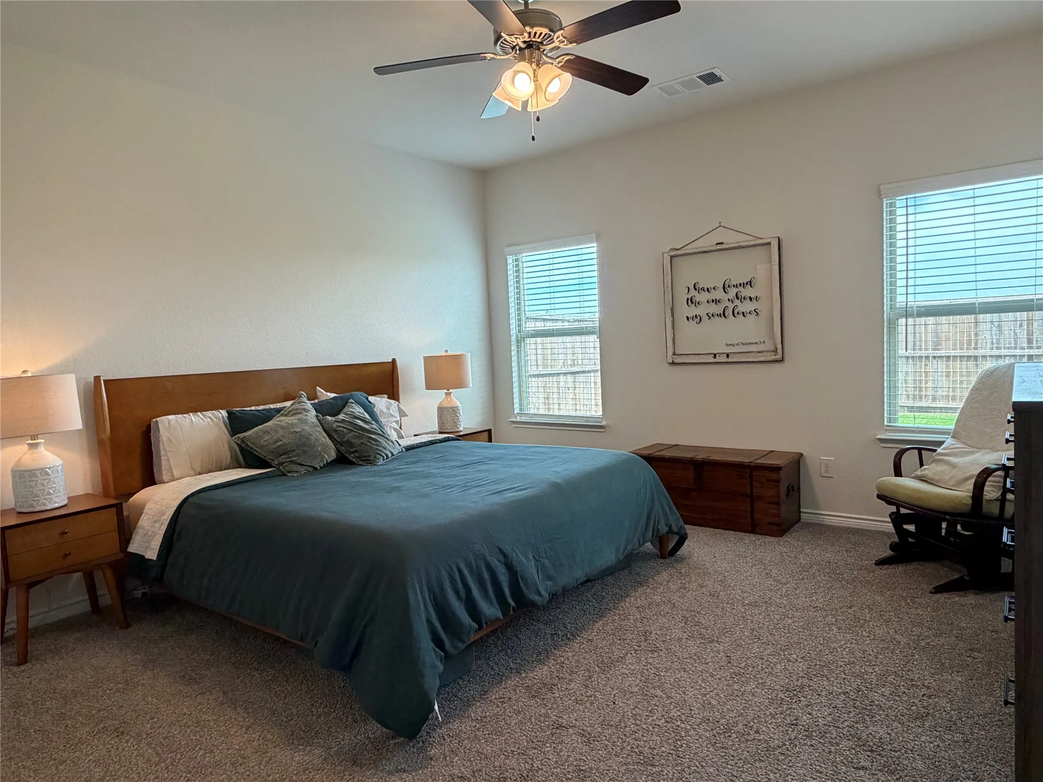 The Primary Suite Serves as a Private Sanctuary with Large Windows Overlooking the Backyard