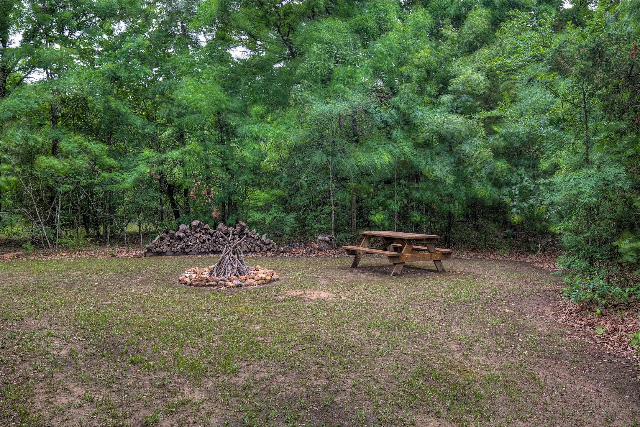Private campground with picnic table, fire ring, and wood rack