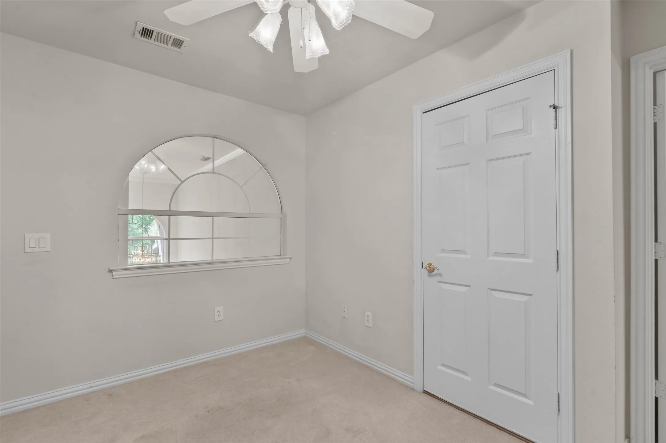 Upstairs bedroom with carpeted flooring and ceiling fan.  The bedroom has a door out to the large covered balcony overlooking the golf course.