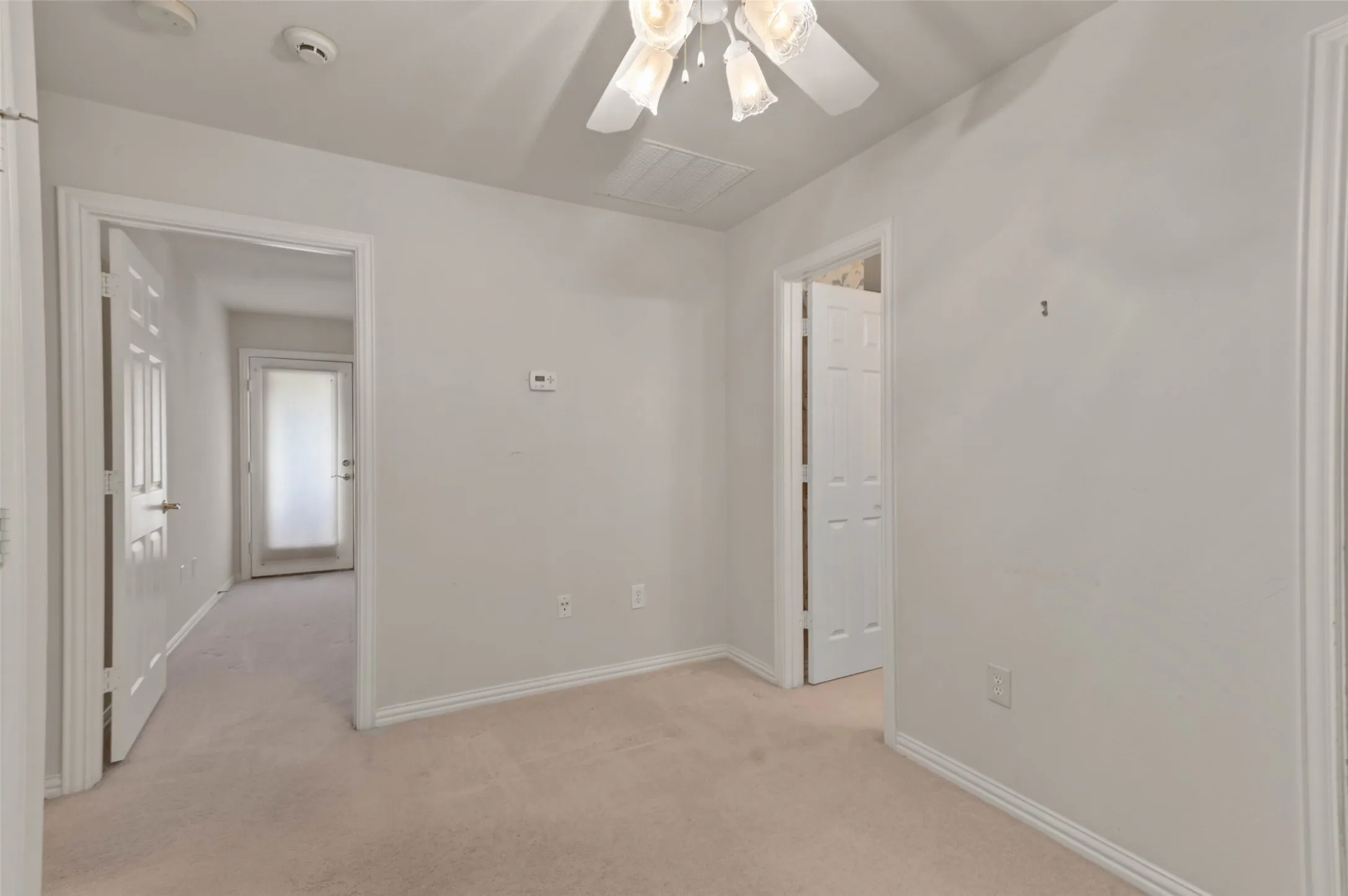 Upstairs sitting area with carpeted flooring and ceiling fan.