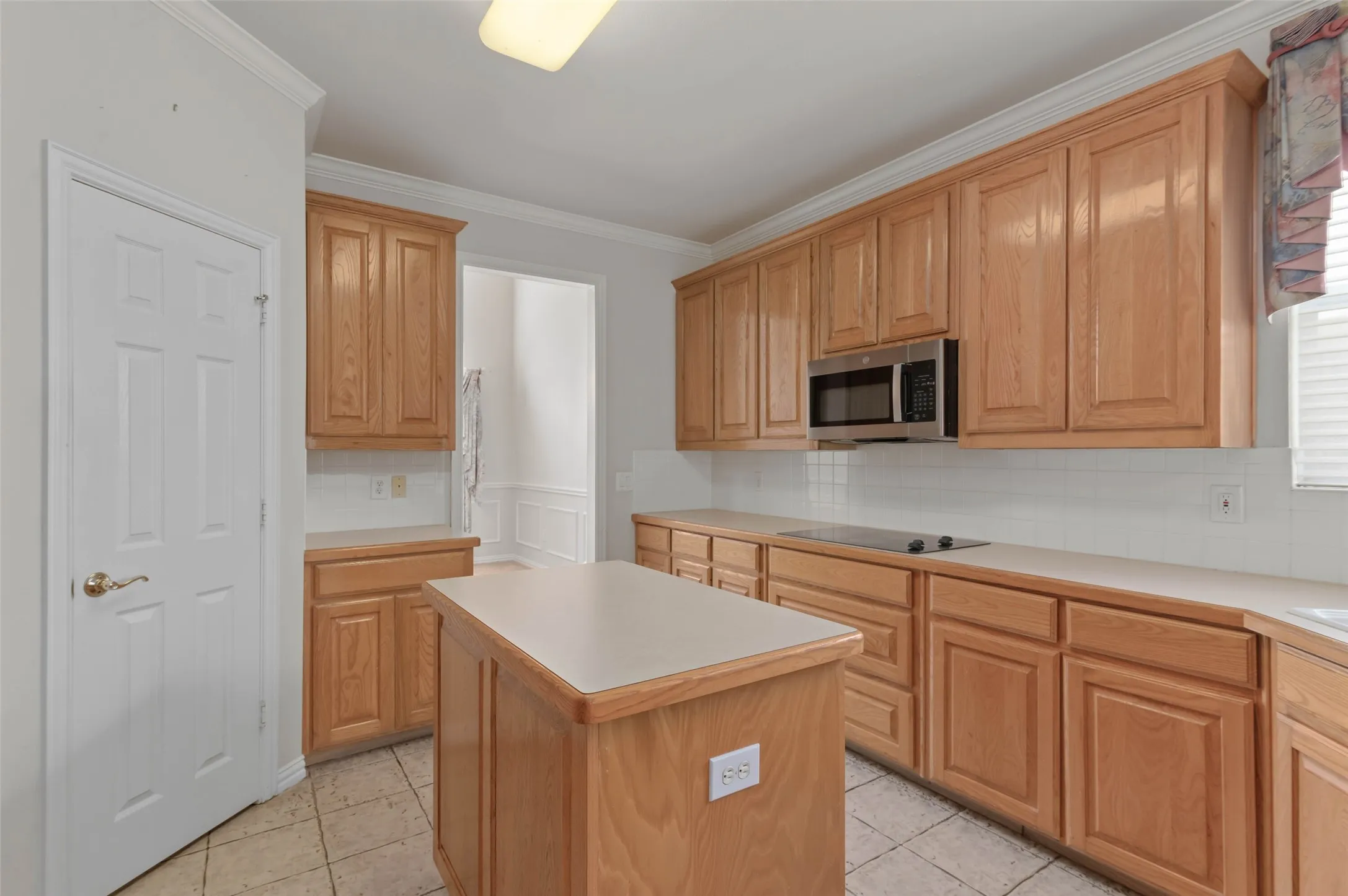 Kitchen with tile flooring, kitchen Island and a huge amount of counter and storage space.