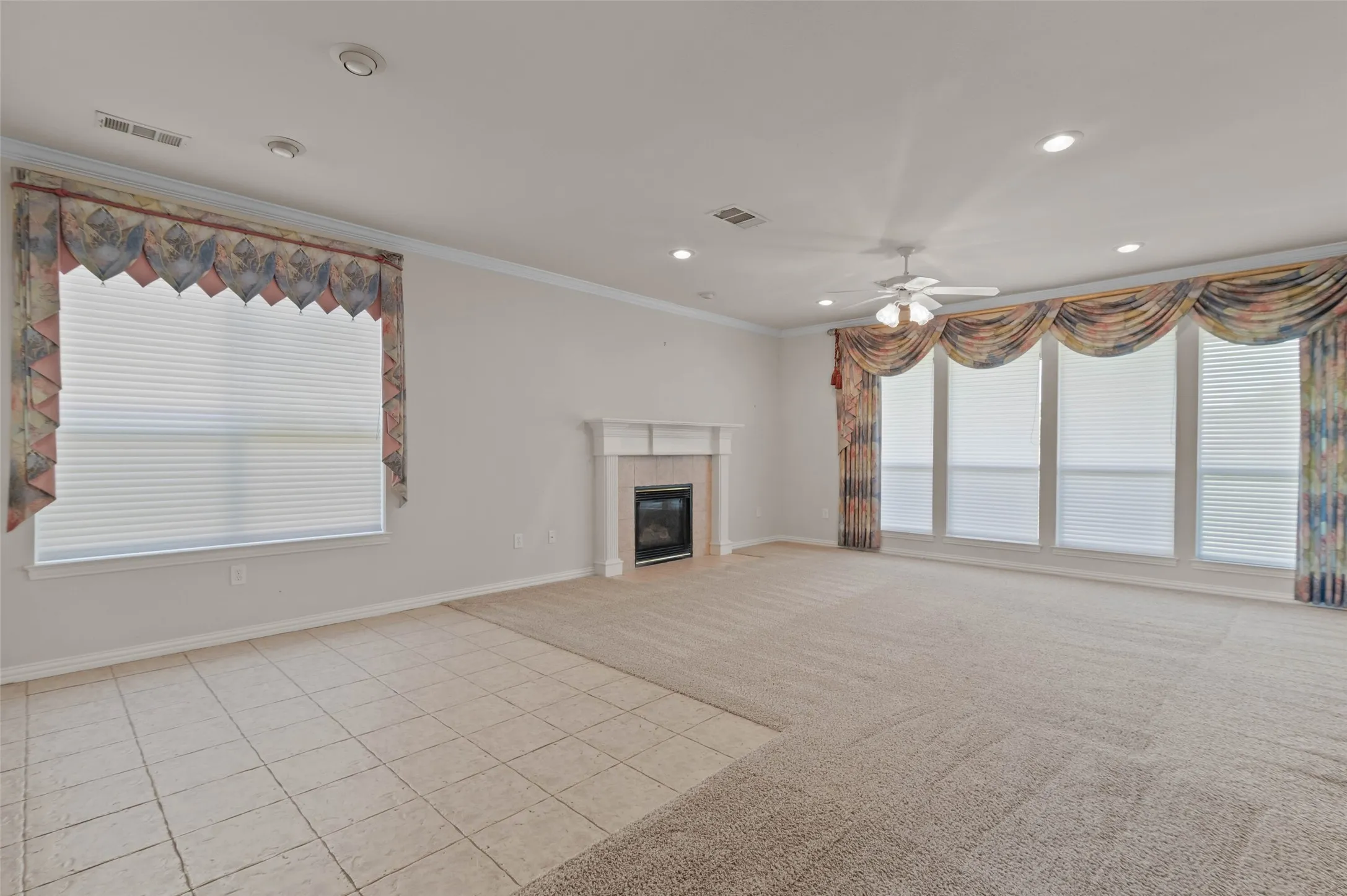 Spacious living room with carpeted flooring and huge windows overlooking the golf course.