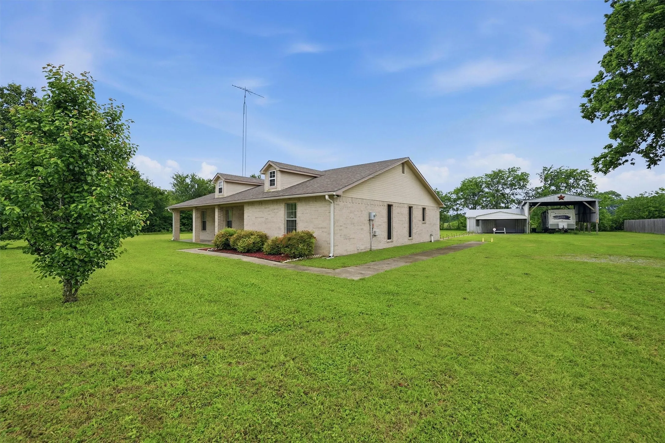 Cream brick exterior with a covered front porch and dormer windows