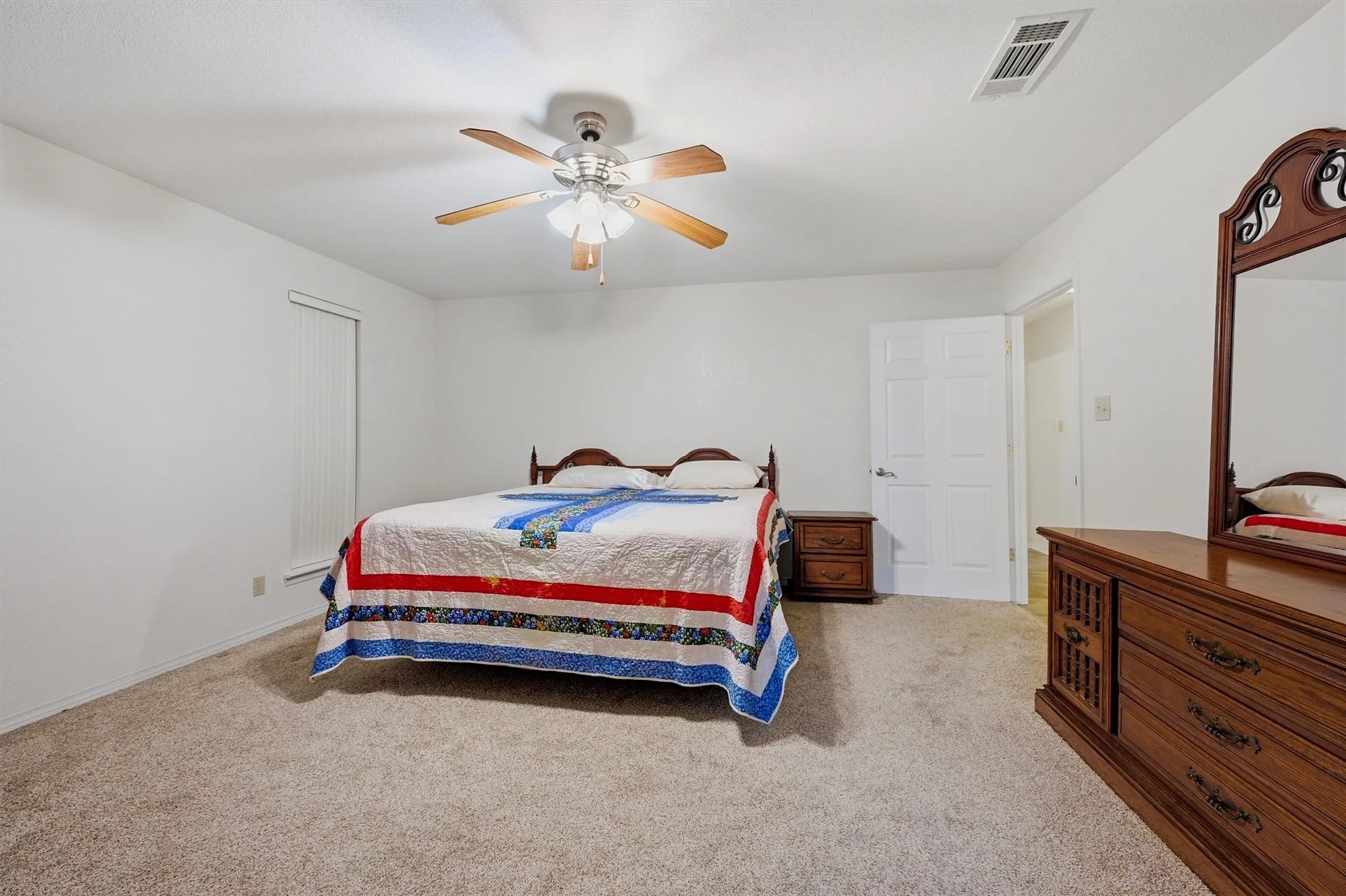 Spacious room featuring neutral carpet flooring and white walls