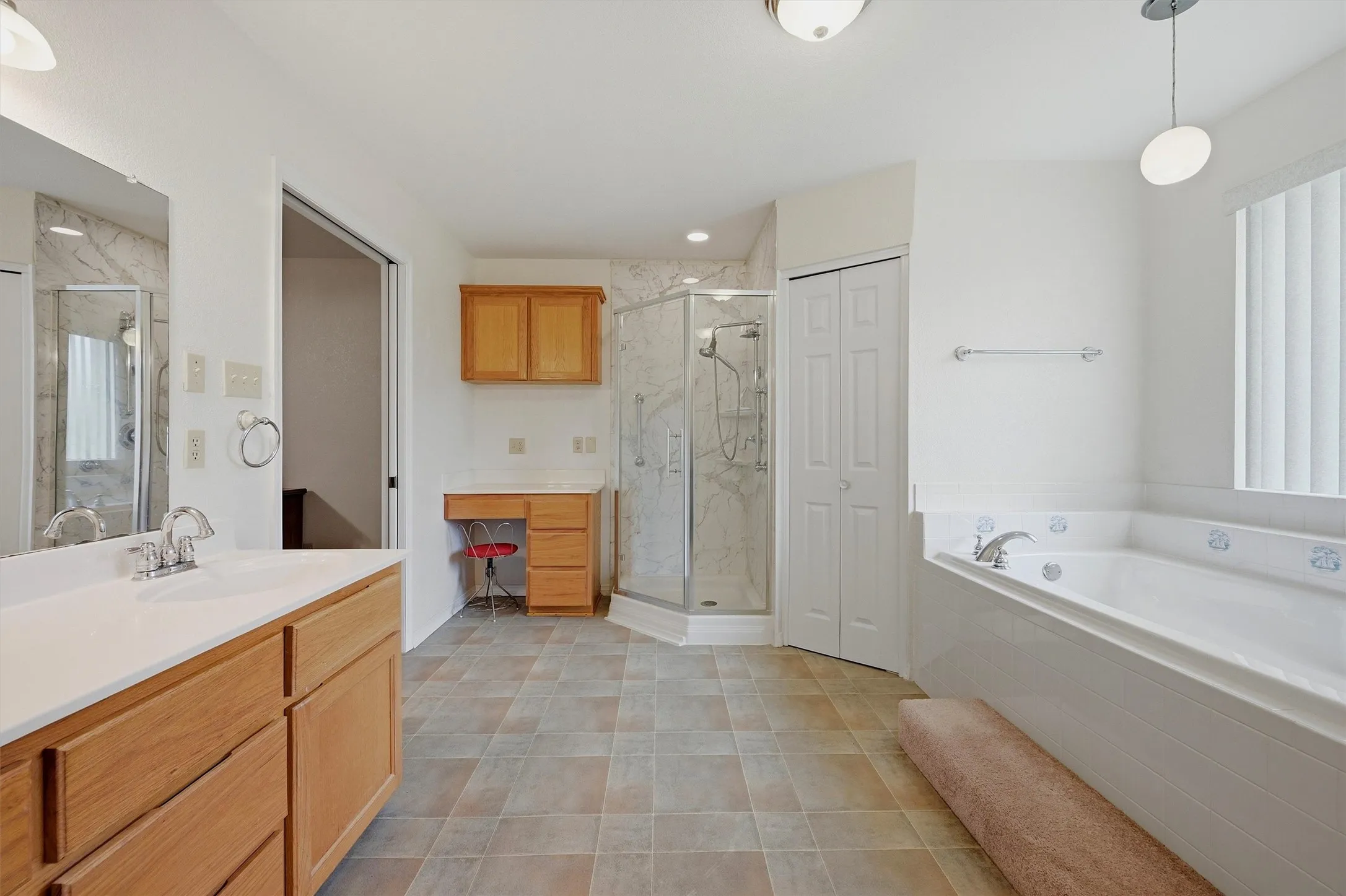 Spacious bathroom with neutral tile flooring