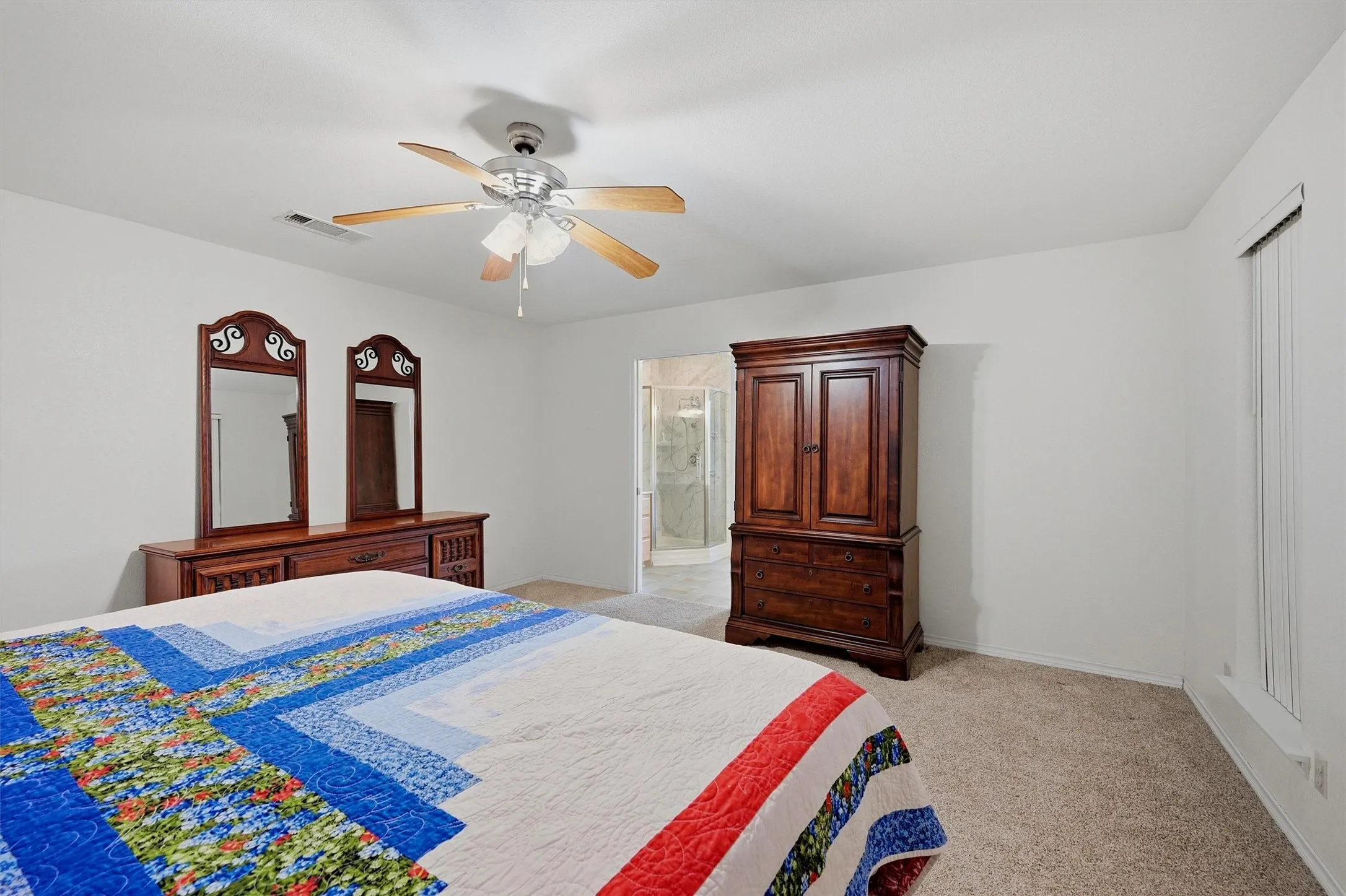 Carpeted bedroom featuring a ceiling fan with light fixture, neutral wall finishes, and a window with blinds