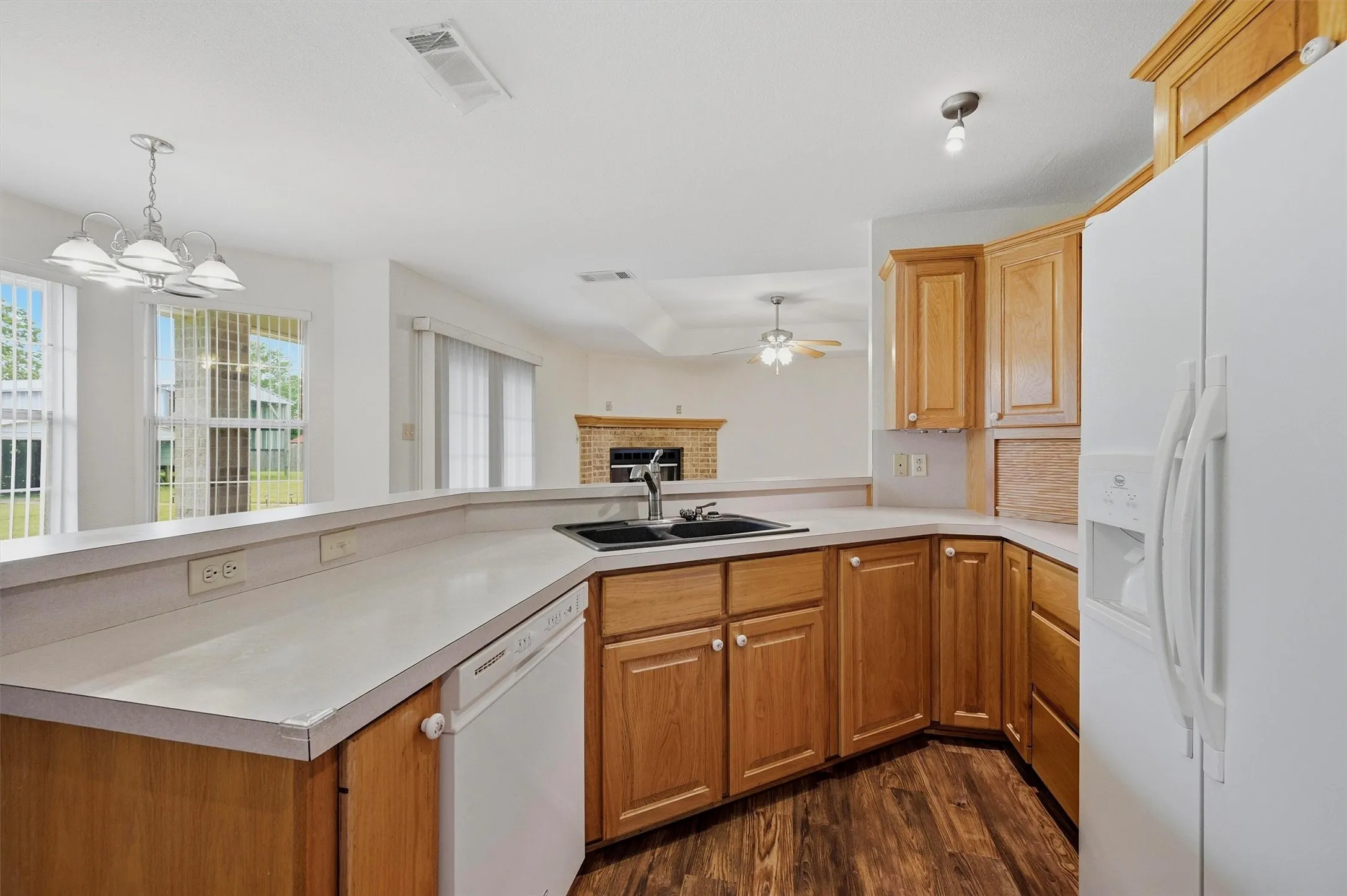 Kitchen featuring wood-finish flooring, light-toned cabinetry, light countertops, and a double basin sink