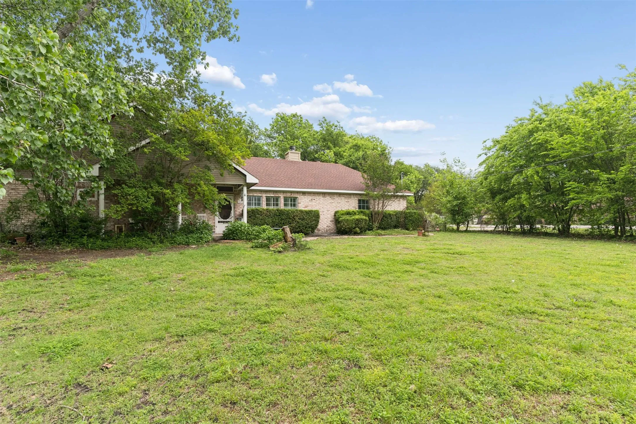 Spacious front lawn with established landscaping and mature trees