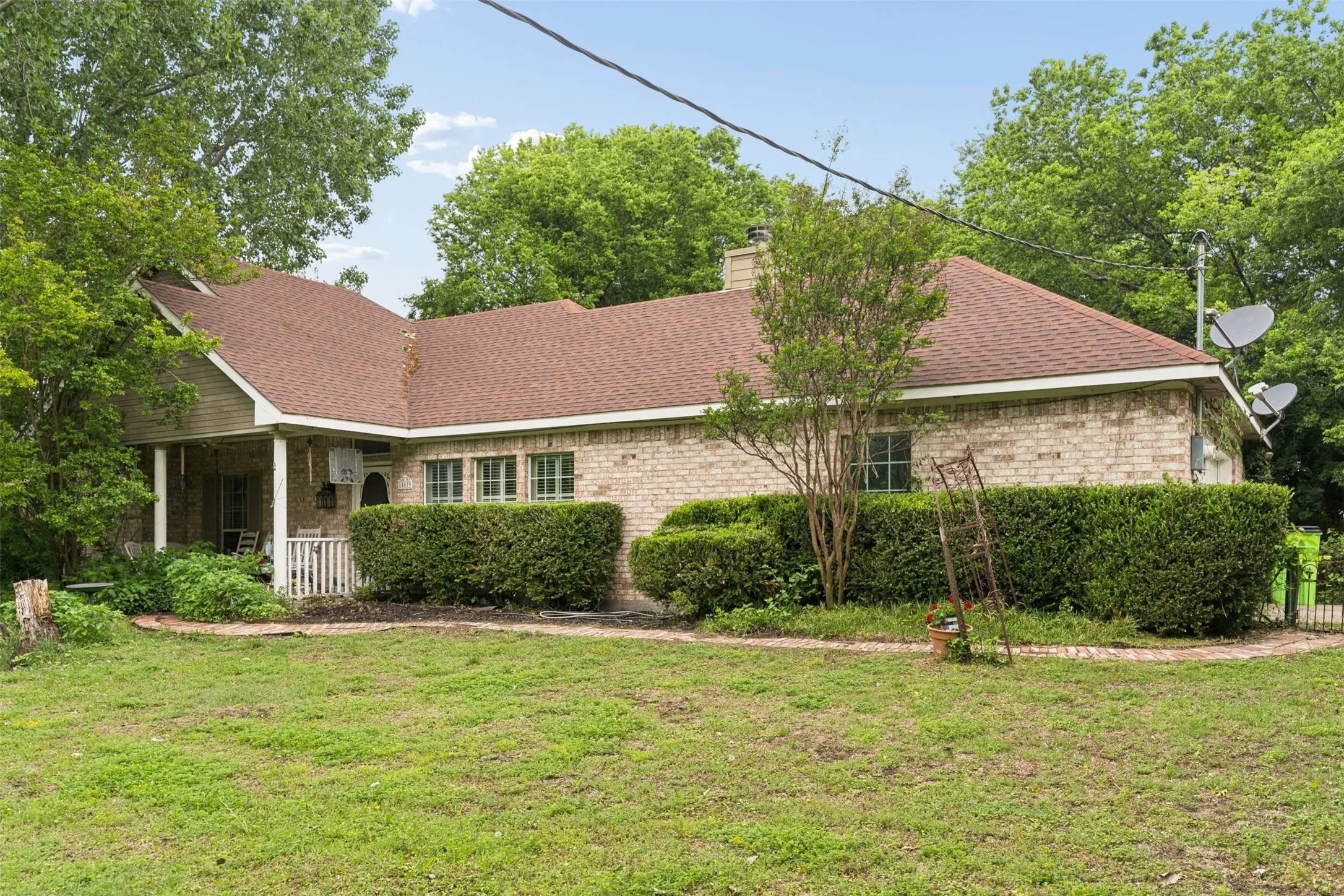 Brick exterior residence with a brown shingle roof