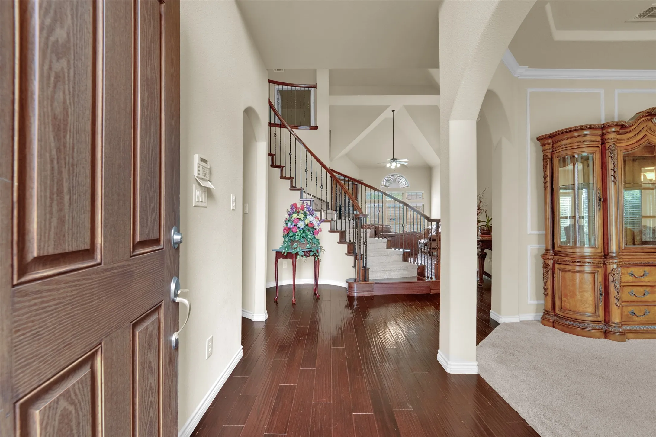 Wood-finish flooring throughout the entryway with a paneled front door