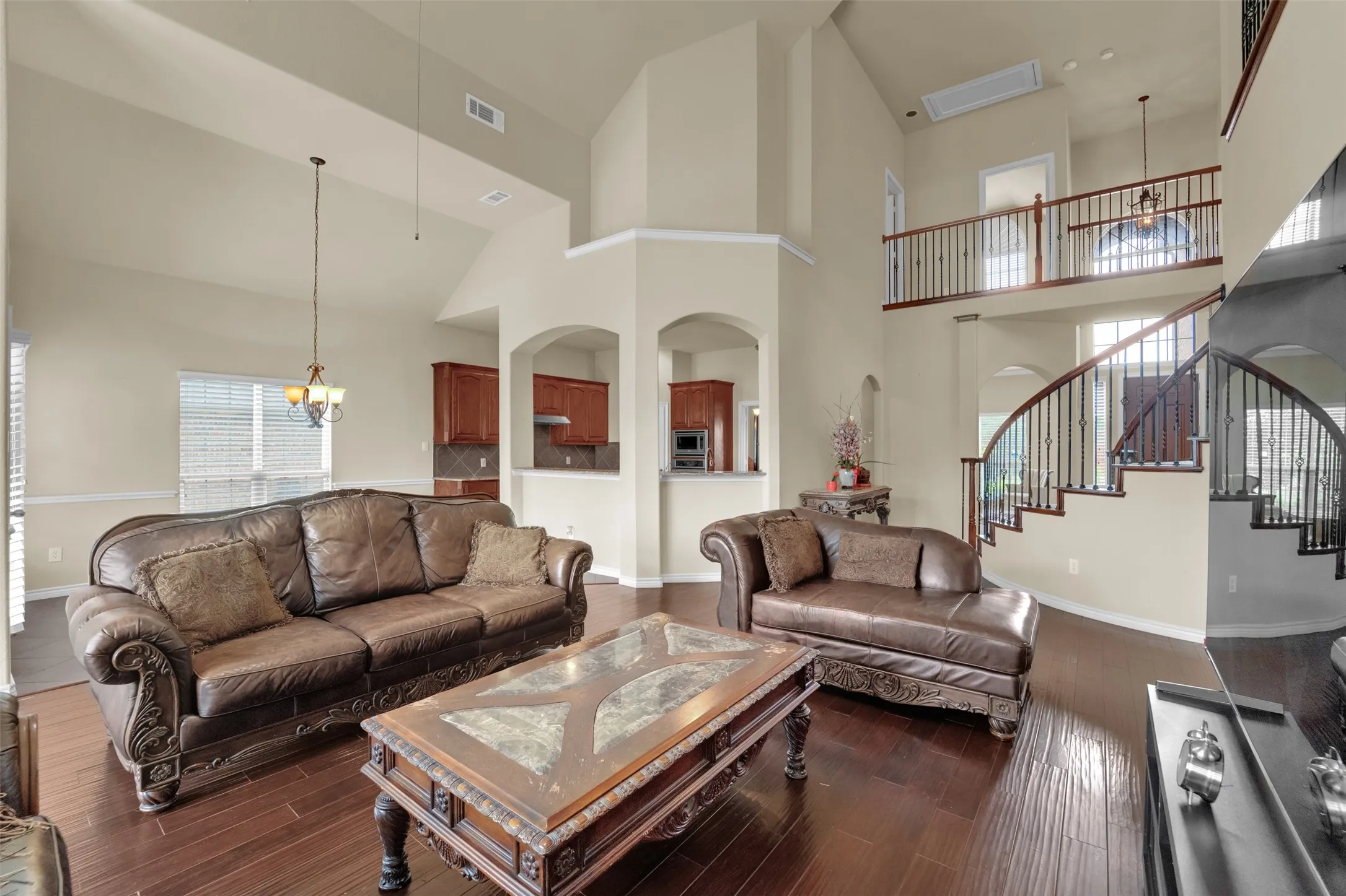 Soaring ceilings complement the wood-finish flooring throughout this open-concept living area