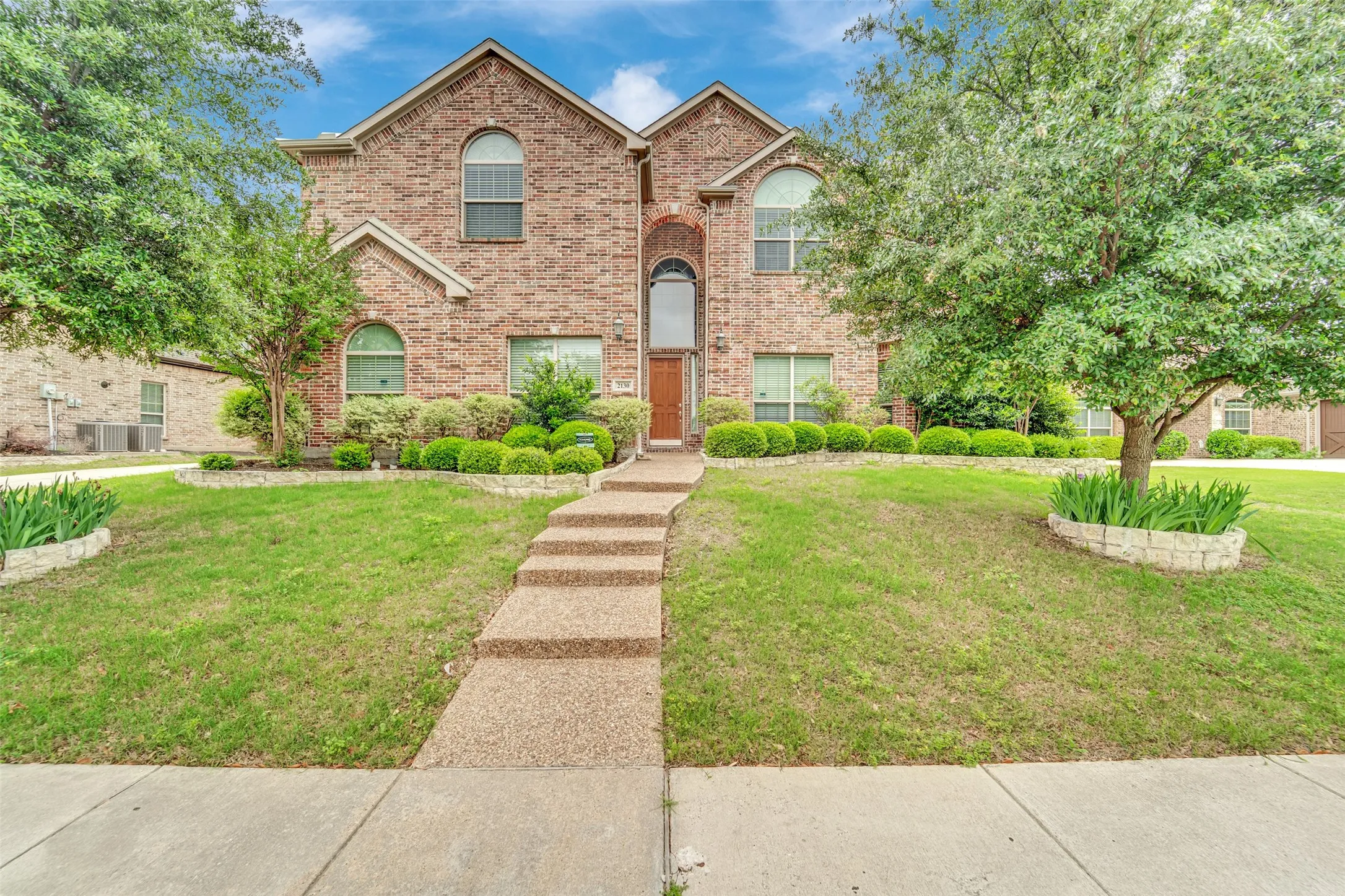 Brick exterior featuring a gabled roofline and arched window details