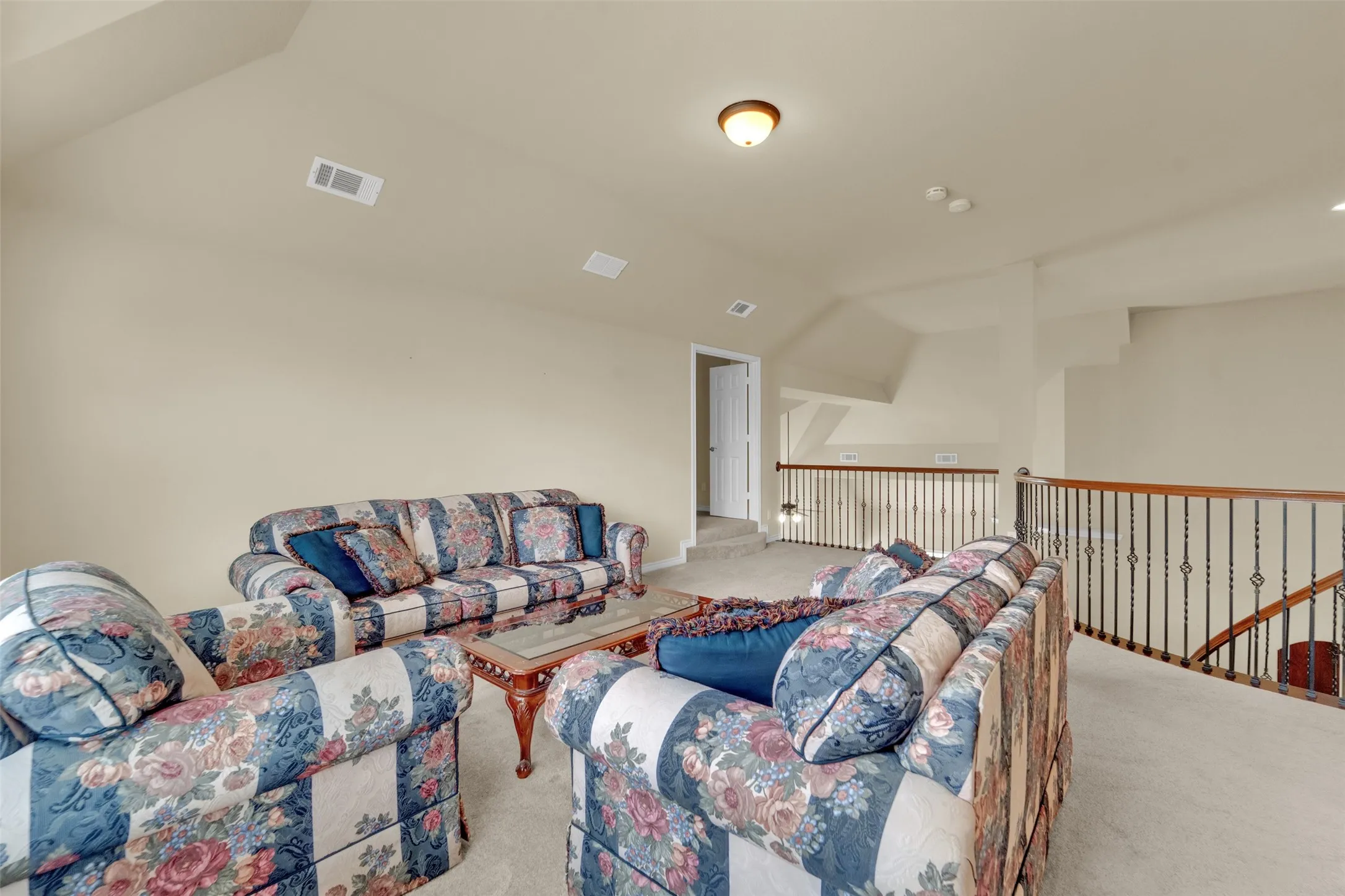 Spacious open loft area featuring sloped ceilings and plush carpeting