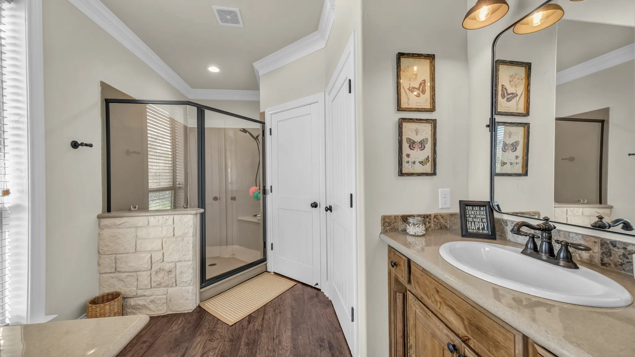 Recently remodeled ensuite bath in the primary bedroom has two separate sinks, shower and toilet area.