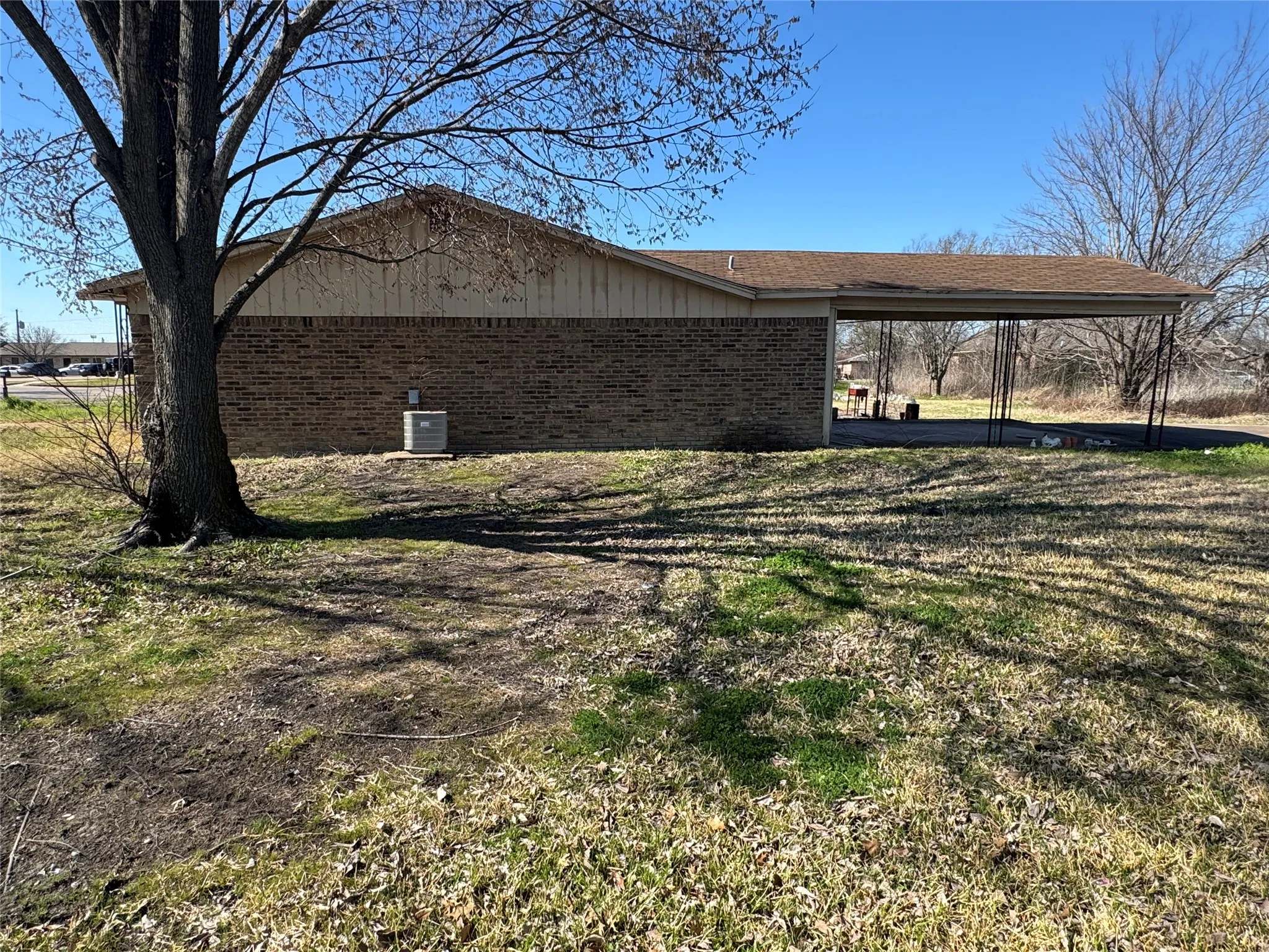 Brick exterior with a carport and a visible HVAC unit