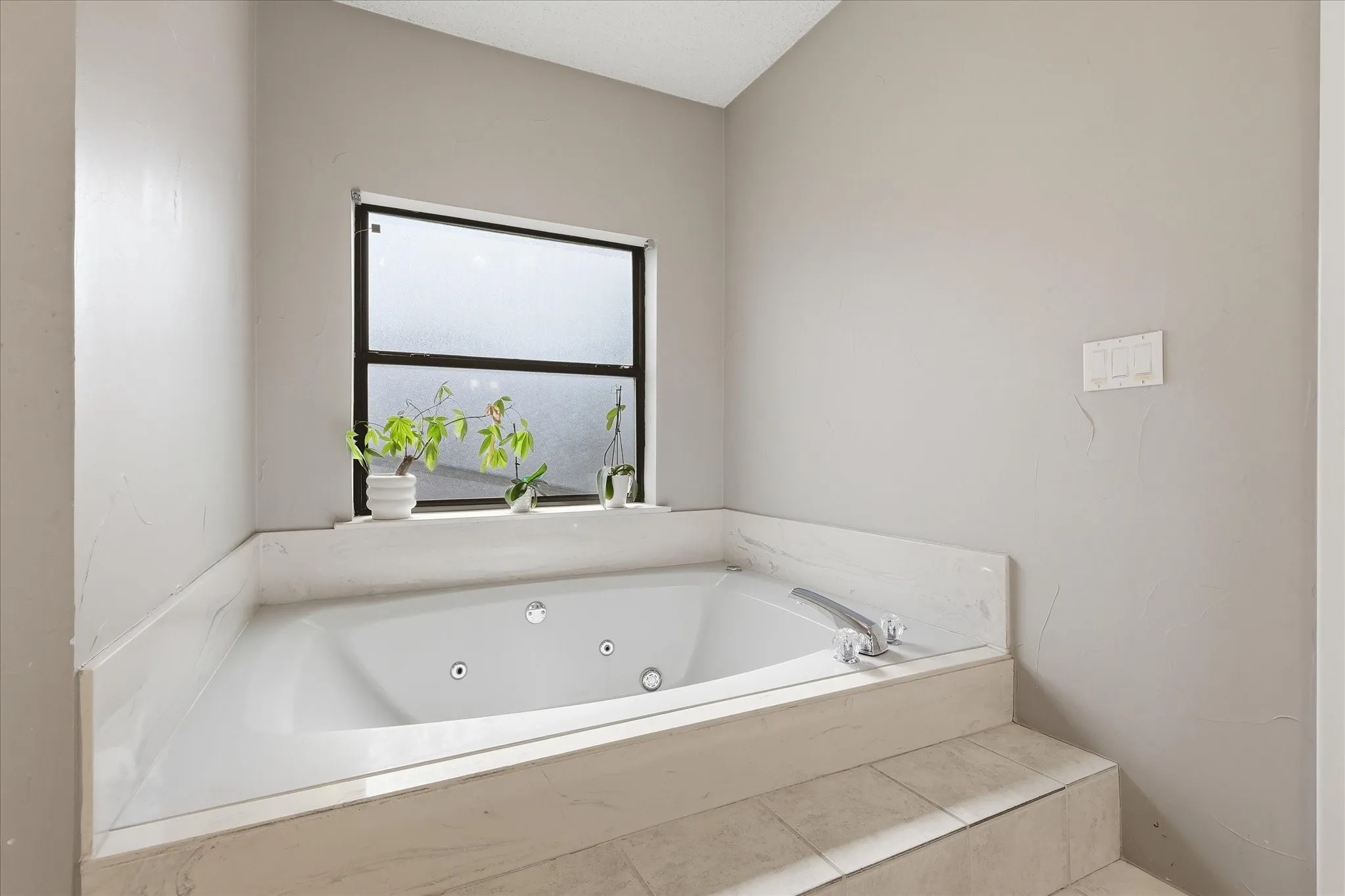 View of oversized, jetted combination tub in the primary bathroom.