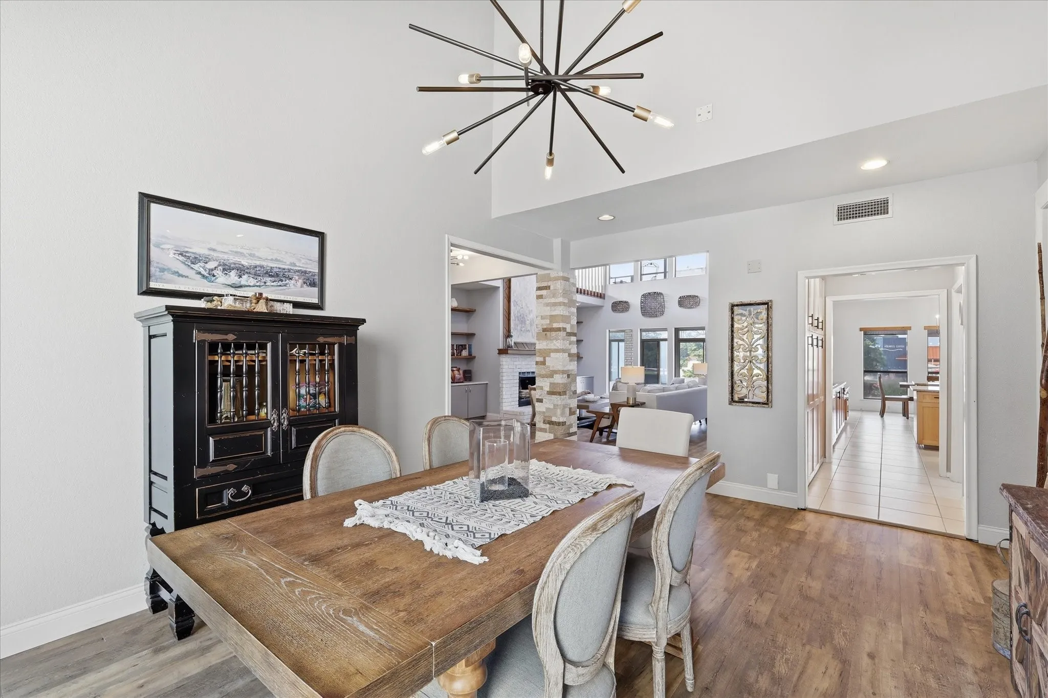 Dining area features a modern light fixture and offers an open connection to both the kitchen and the main living room.