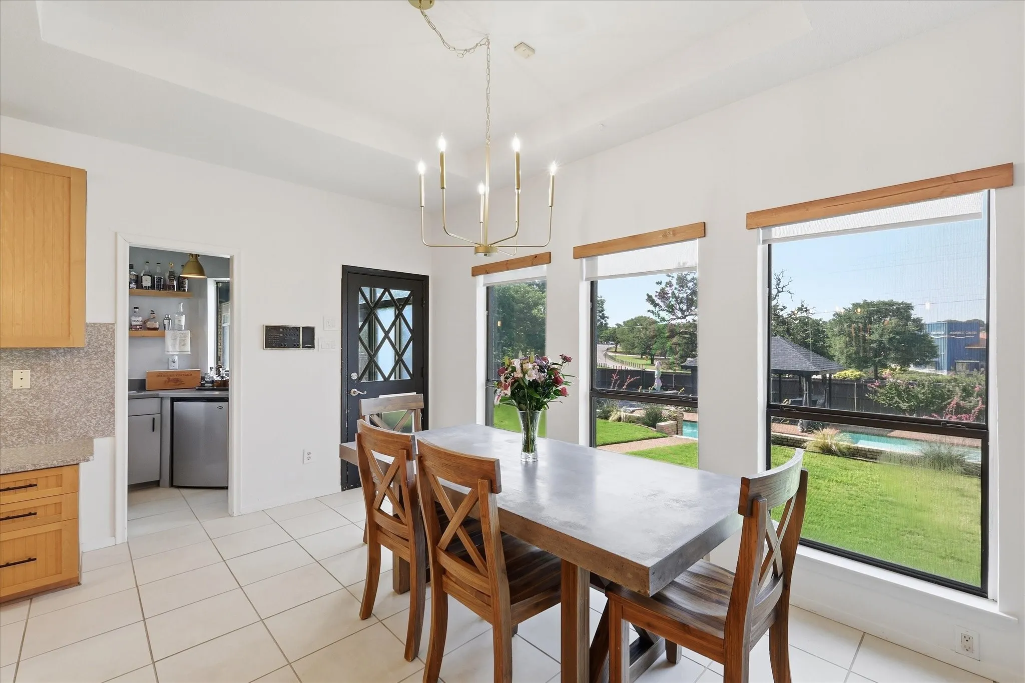 Breakfast area by kitchen overlooks the backyard, pool and sports court.