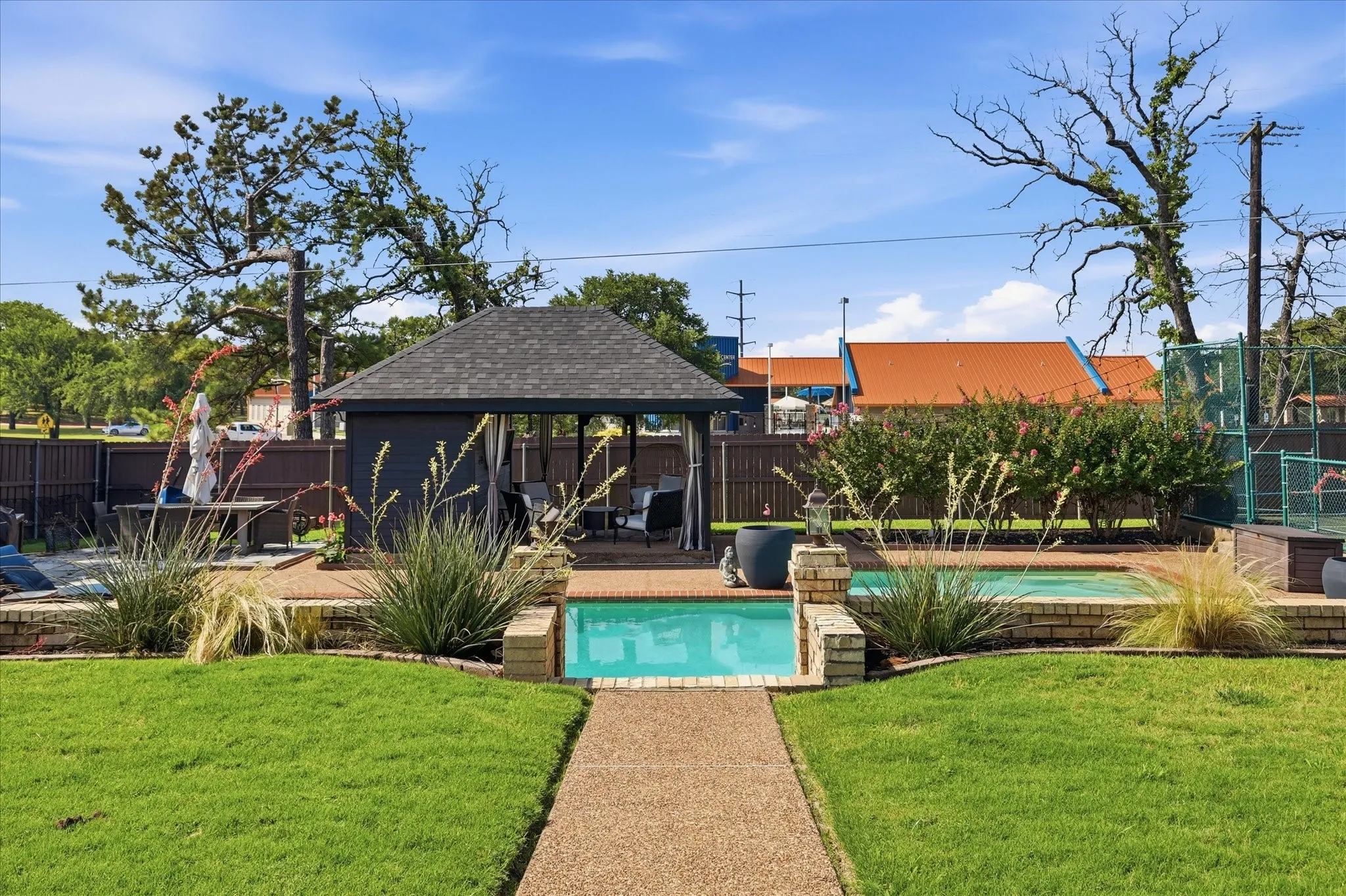 Backyard featuring a removed pool area with cabana and large pool deck.