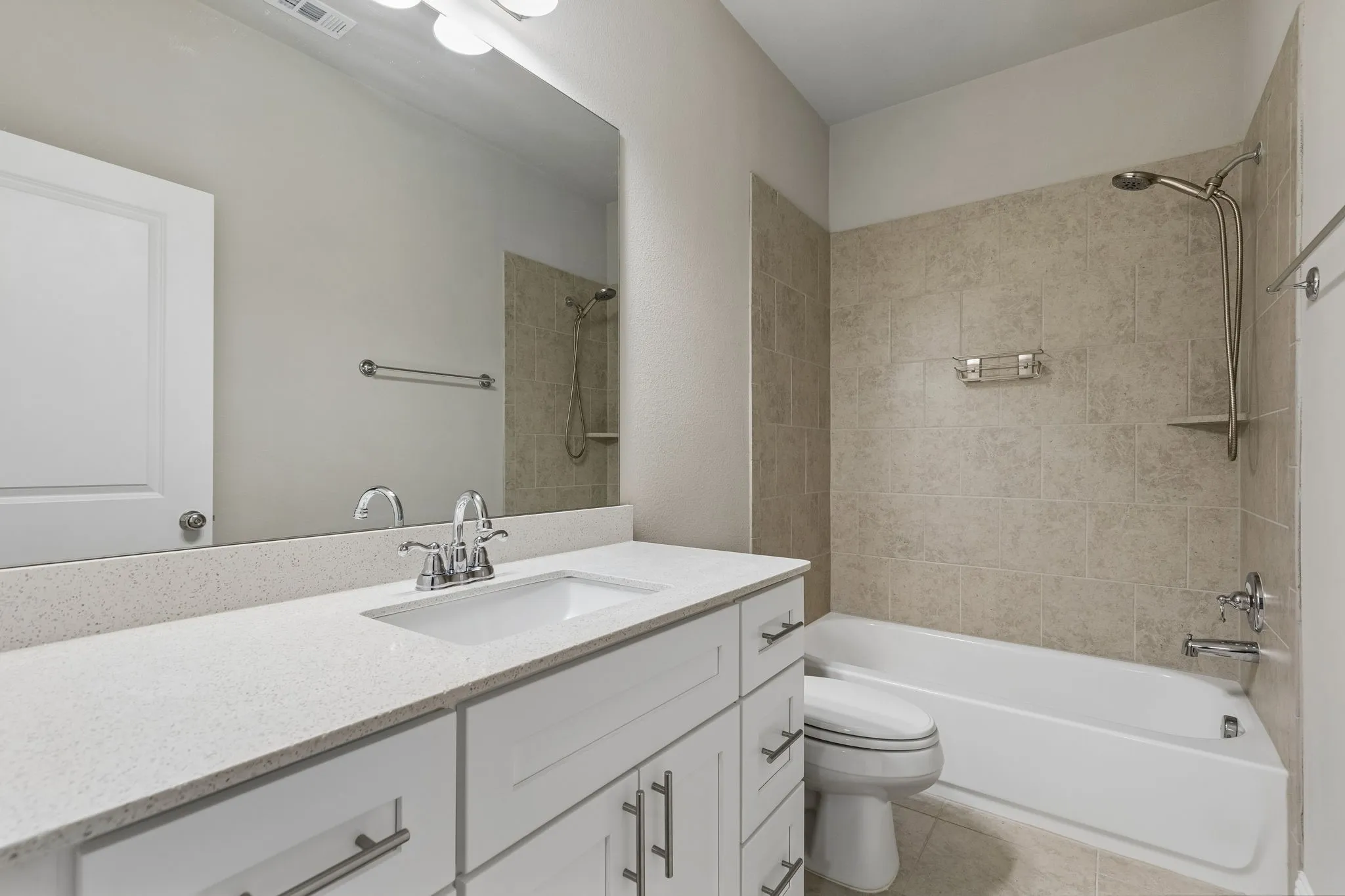 Bathroom featuring a white vanity with a light-toned Quartz countertop, an integrated sink, and chrome fixtures