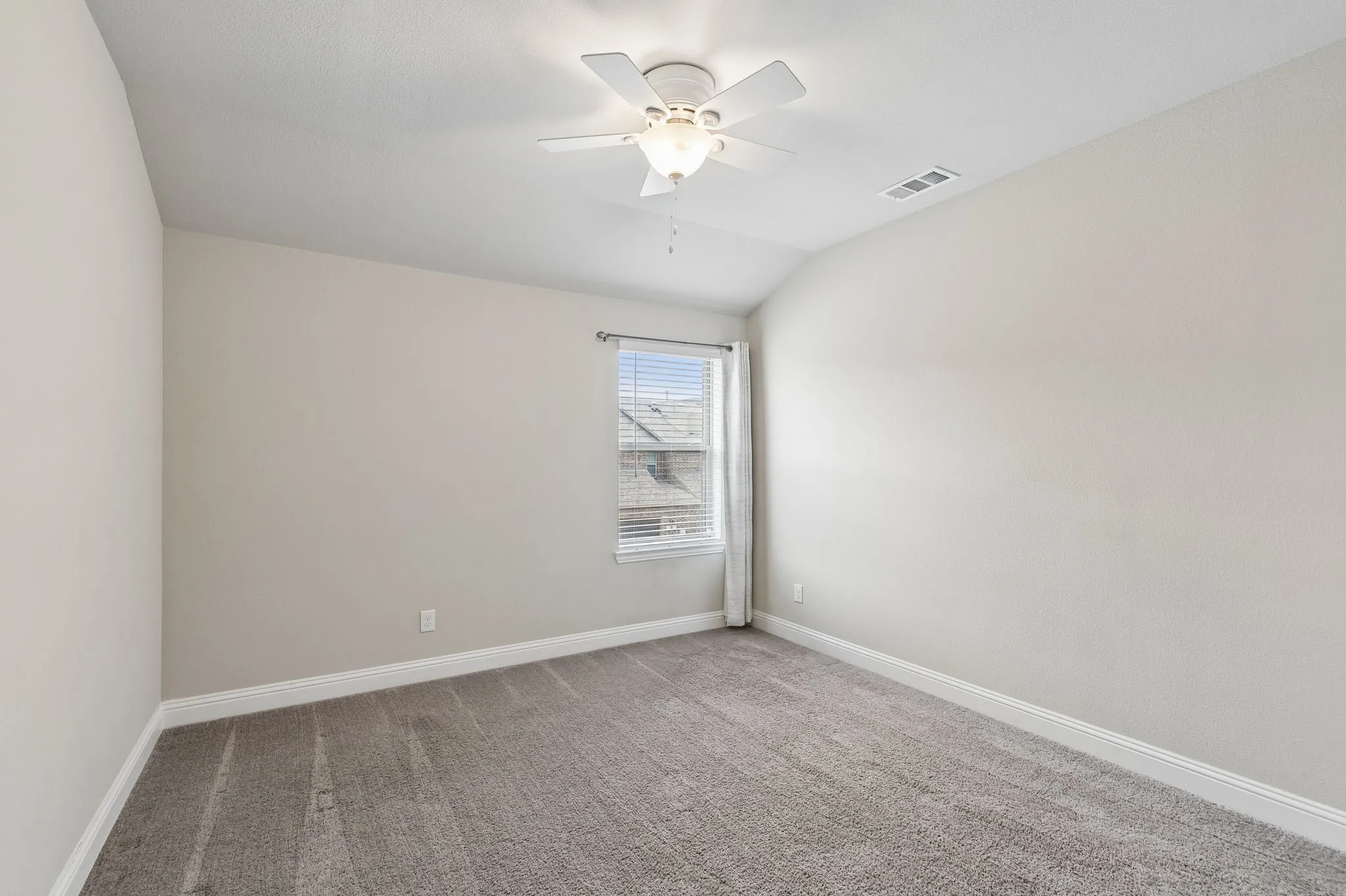 Carpeted room featuring a single window with blinds and drapes, a ceiling fan with integrated lighting, and crown molding