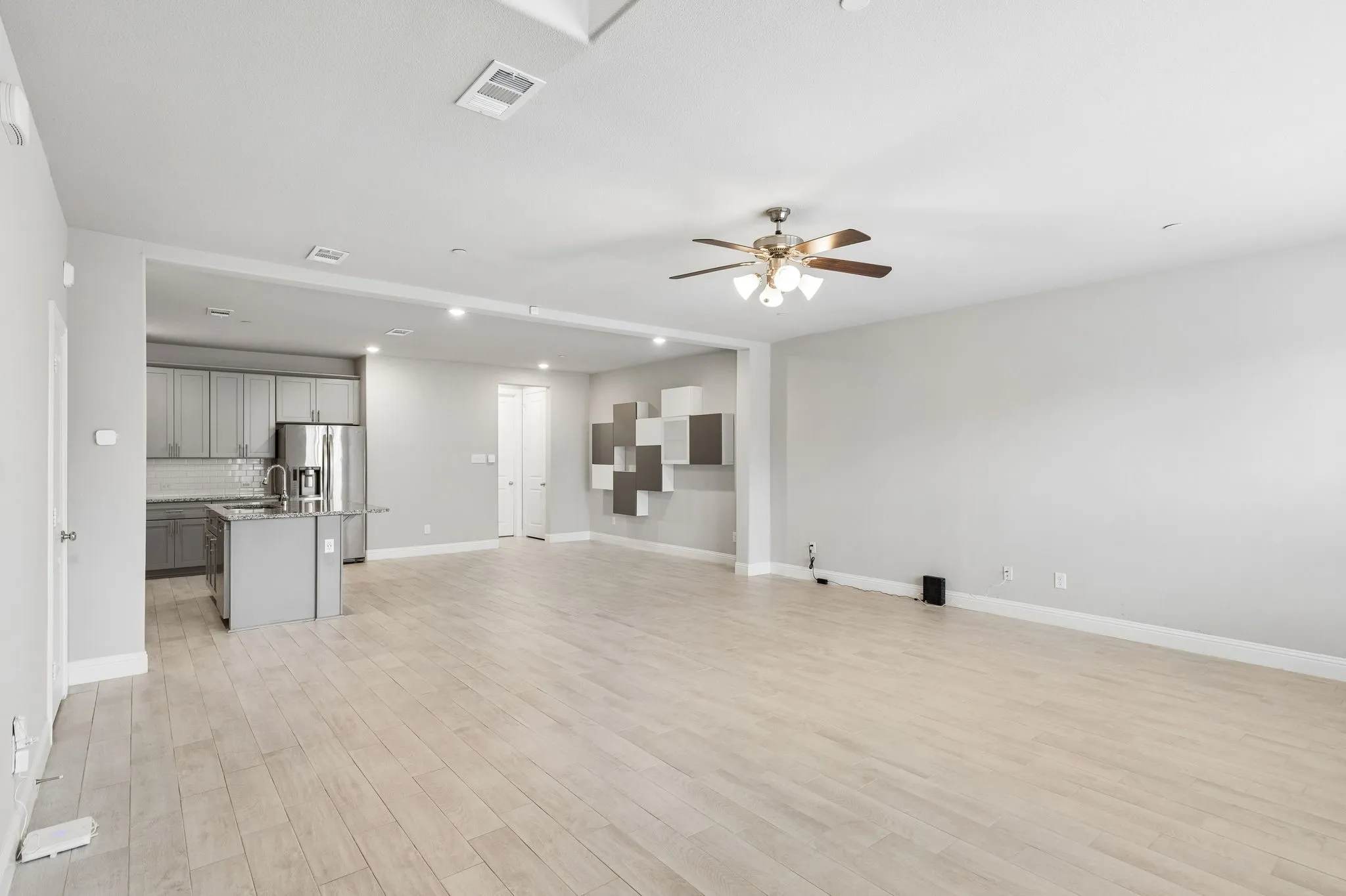 Open-concept living area with light-toned wood-finish flooring