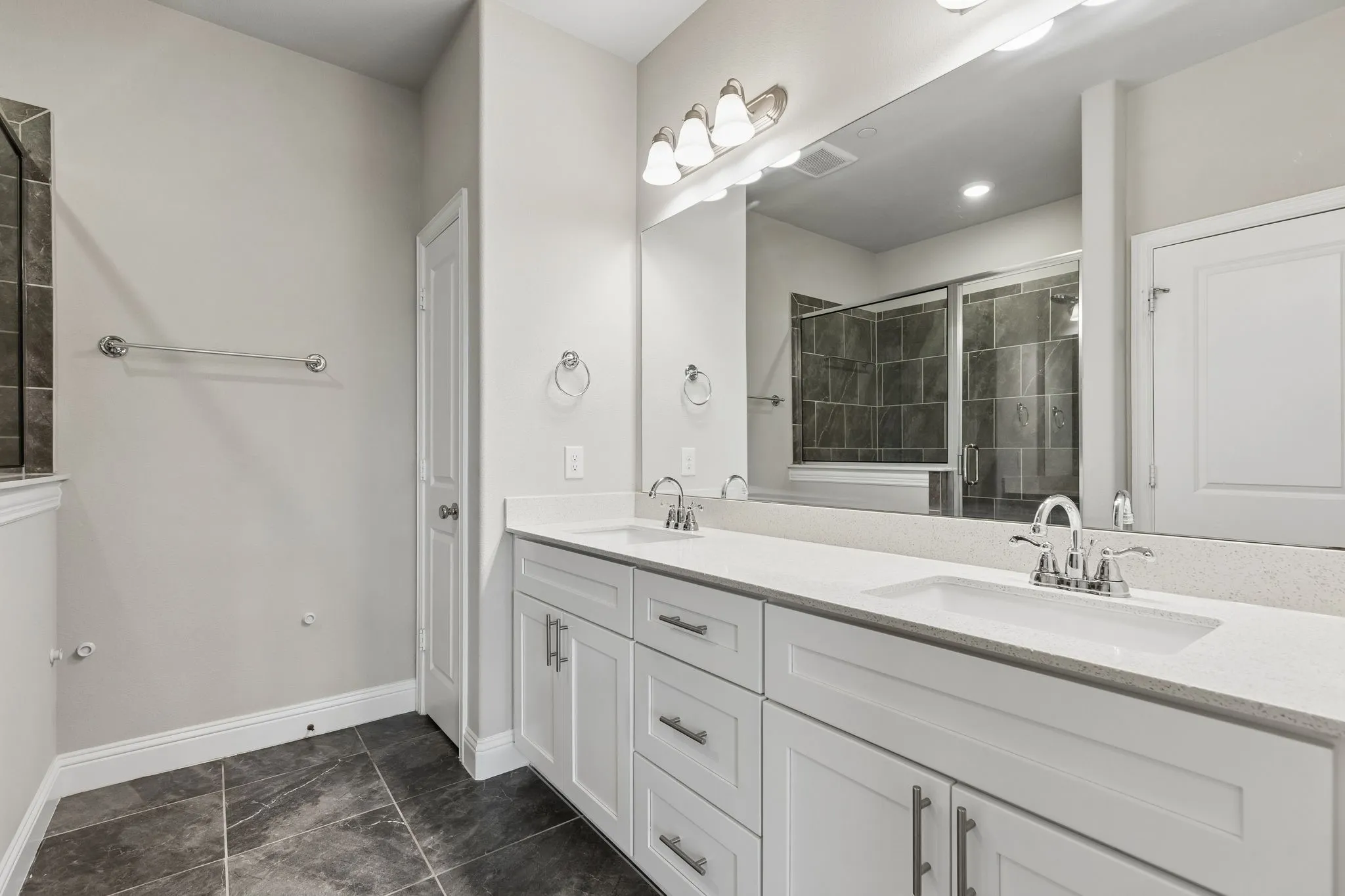 Dual vanity with white cabinetry and integrated sinks set in a light-toned Quartz countertop