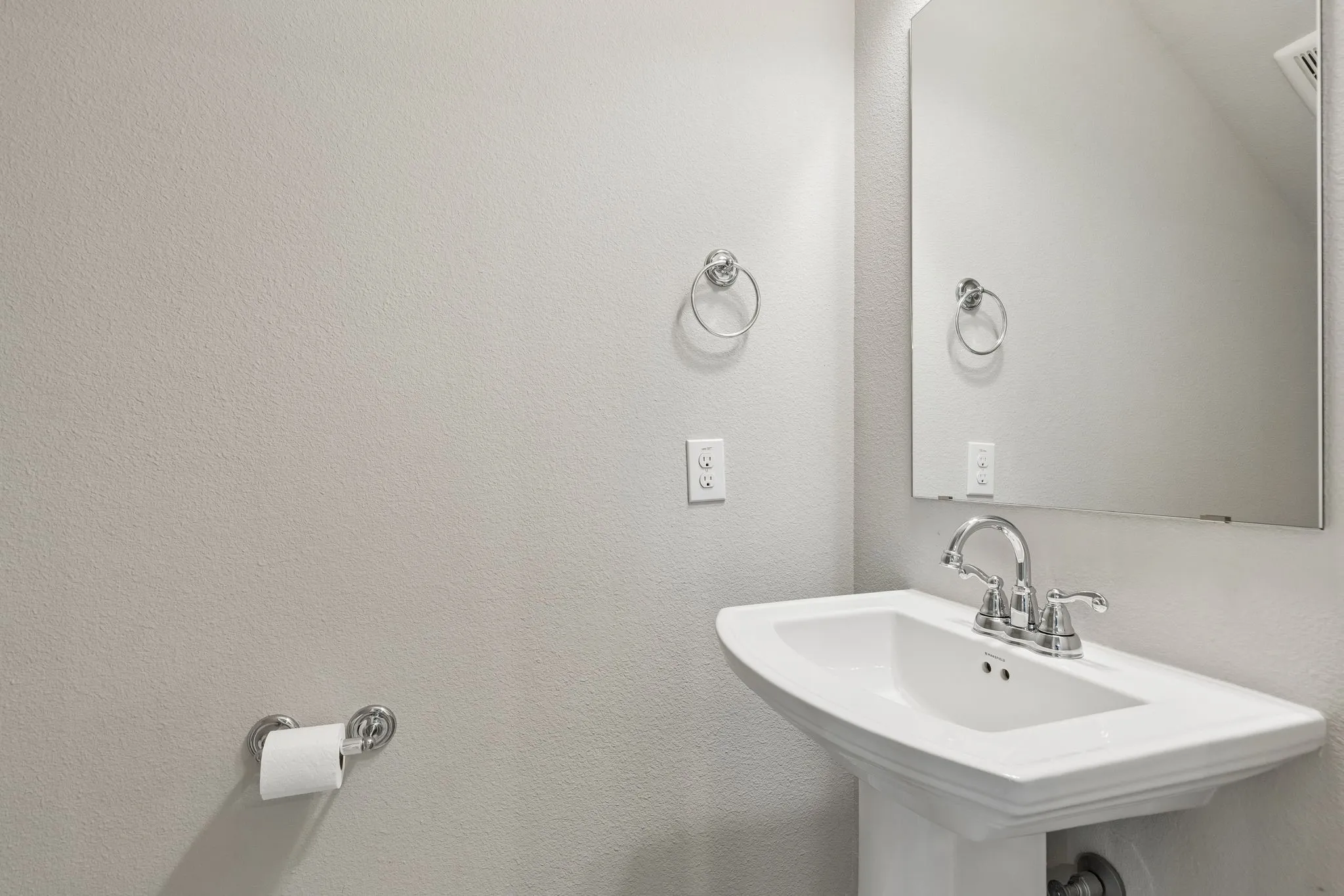 White pedestal sink with chrome faucet.