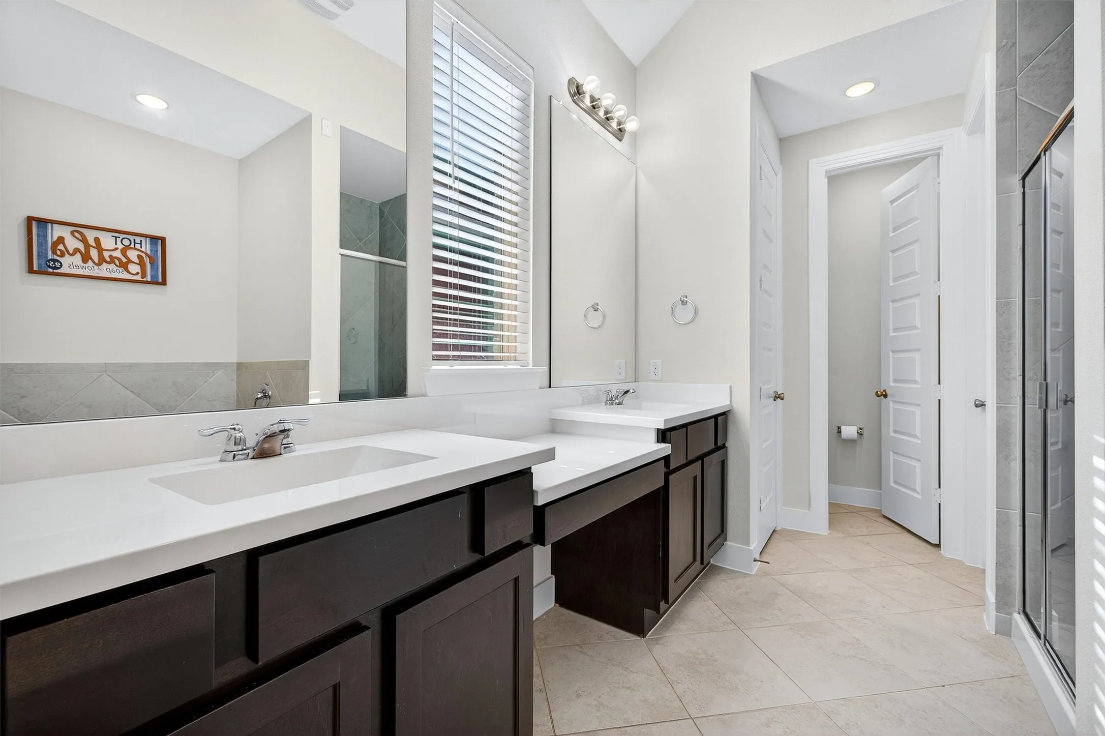 Full bathroom with a shower stall, double vanity, light tile patterned floors, and recessed lighting