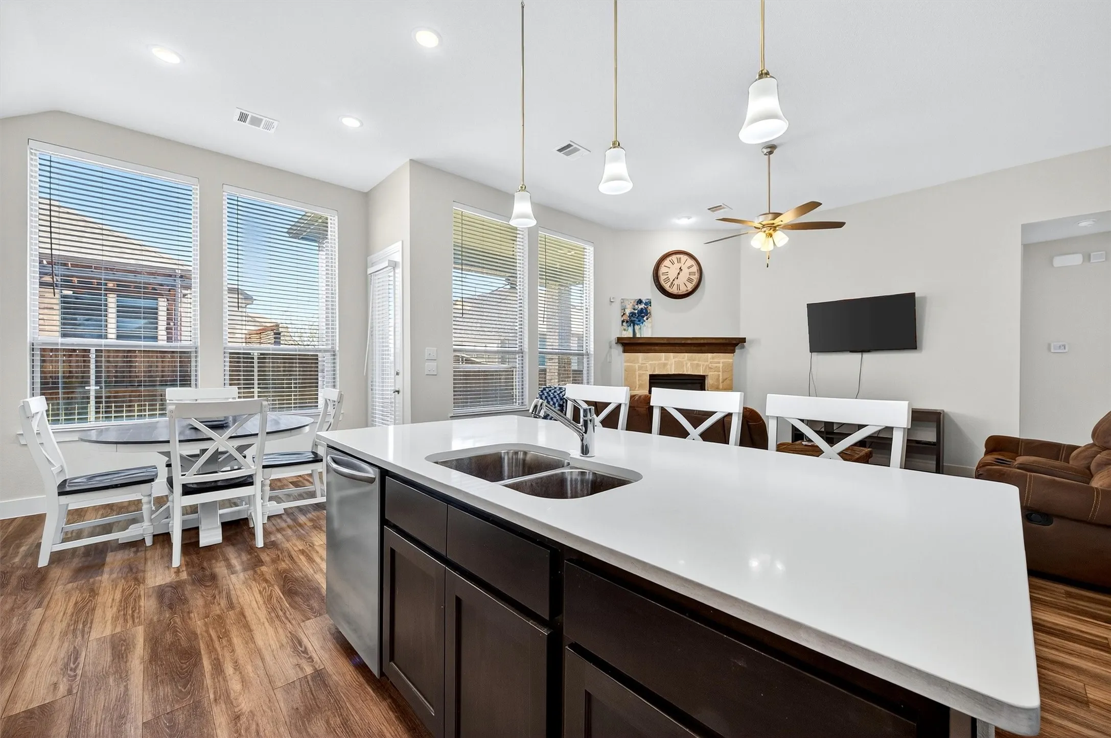 Kitchen featuring open floor plan, a fireplace, hanging light fixtures, dark wood-style floors, and recessed lighting
