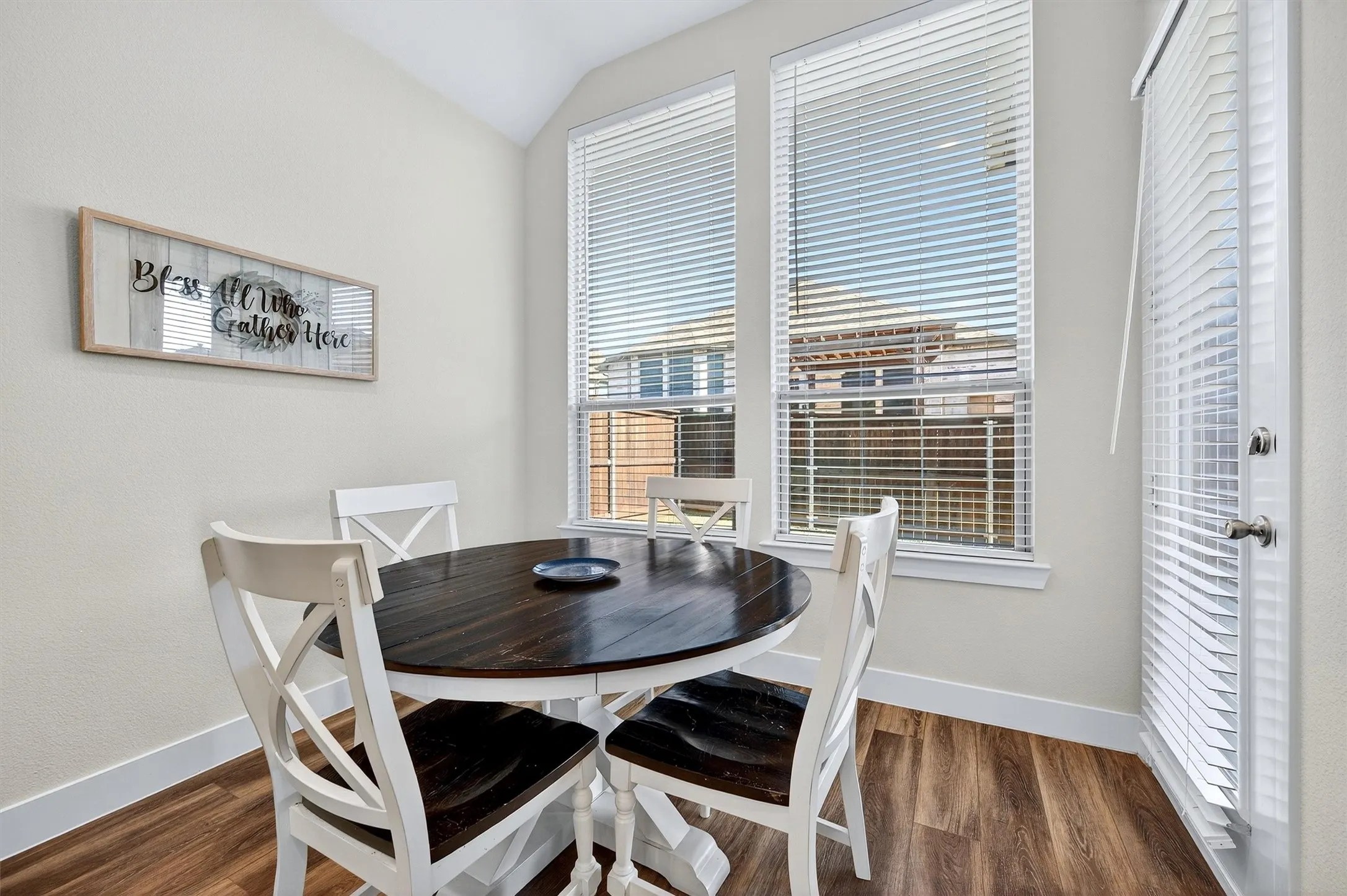 Dining area with dark wood-style flooring and lofted ceiling