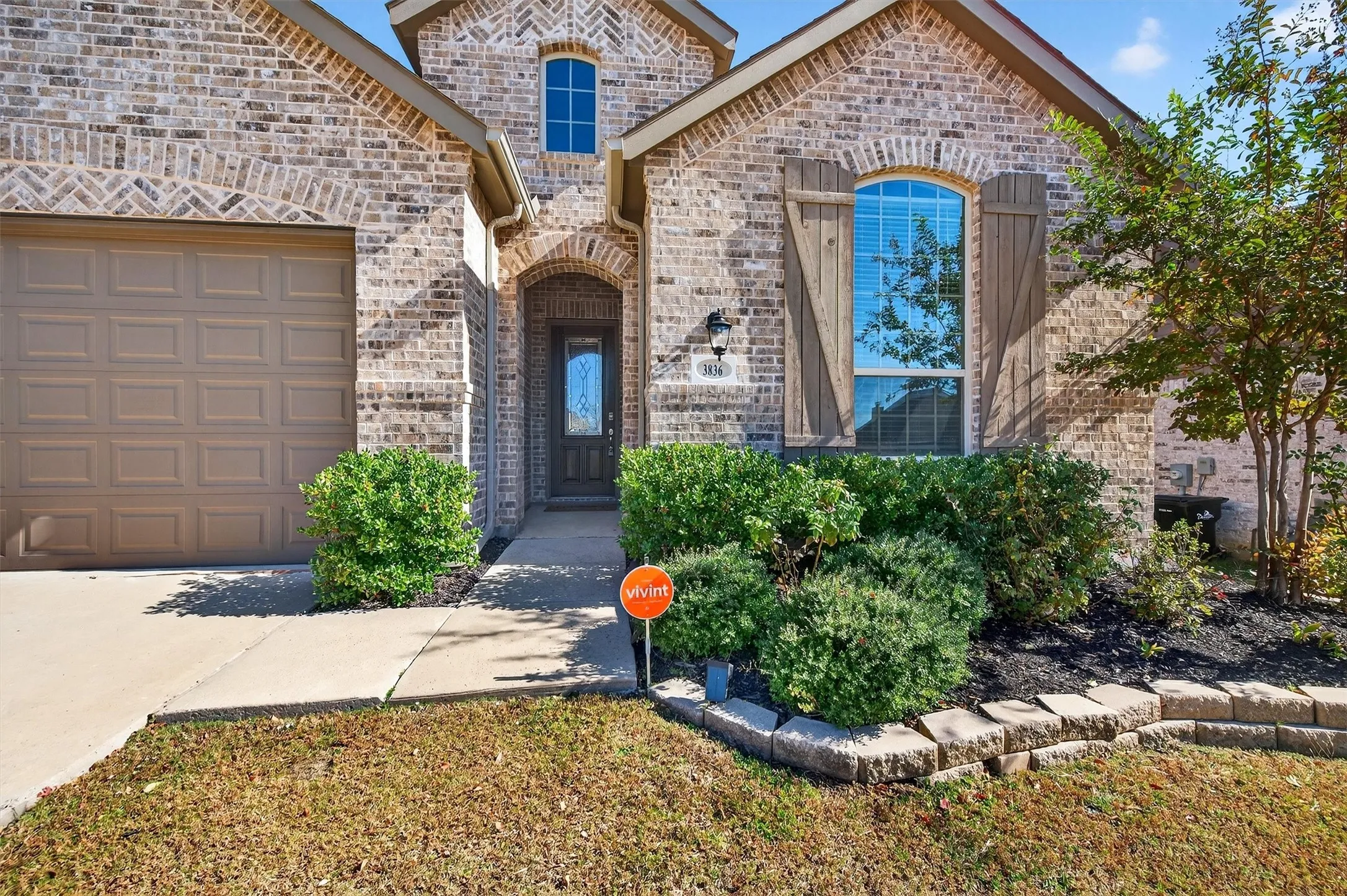 View of front of home featuring brick siding and a garage