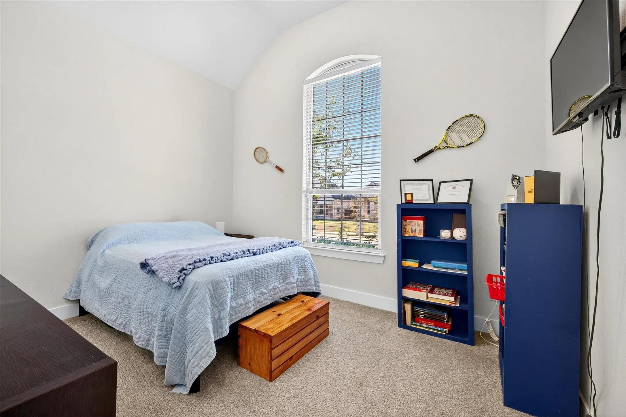 Bedroom with light carpet and lofted ceiling
