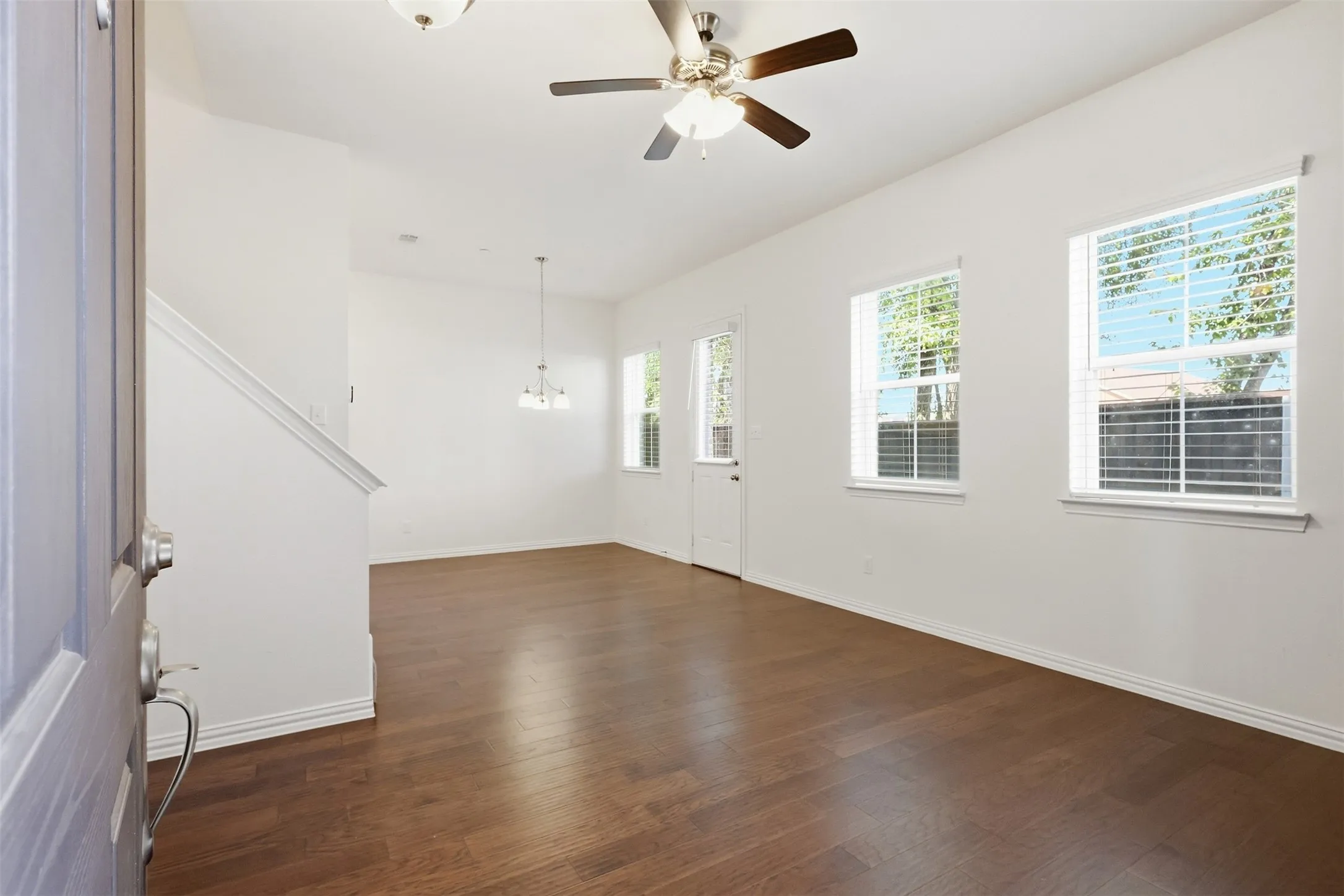 Open concept living area with wood flooring and access to private backyard