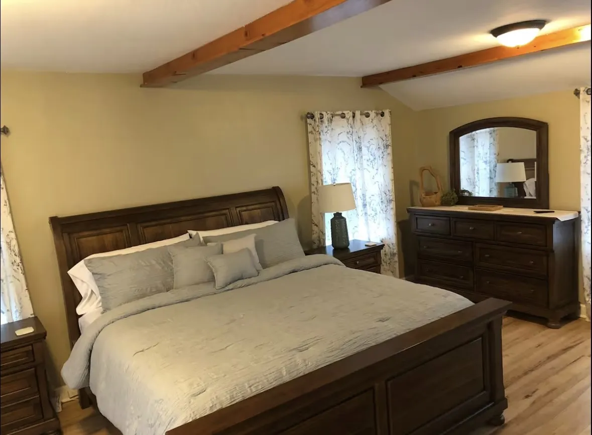 Second floor Bedroom featuring exposed ceiling beams, wood-finish flooring, and light-colored walls