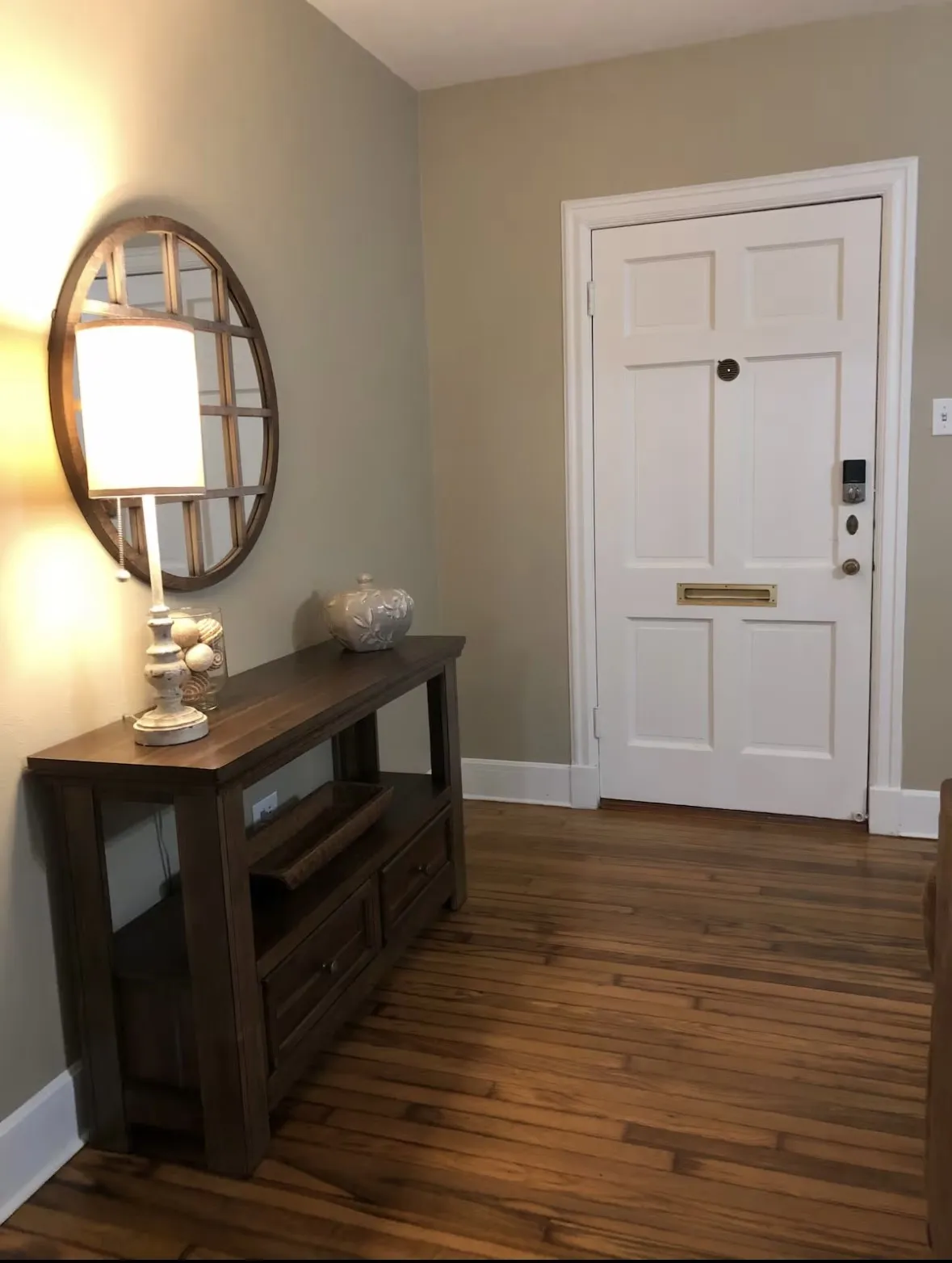 Entryway featuring wood  flooring, a white paneled door with smart lock hardware, and neutral wall paint