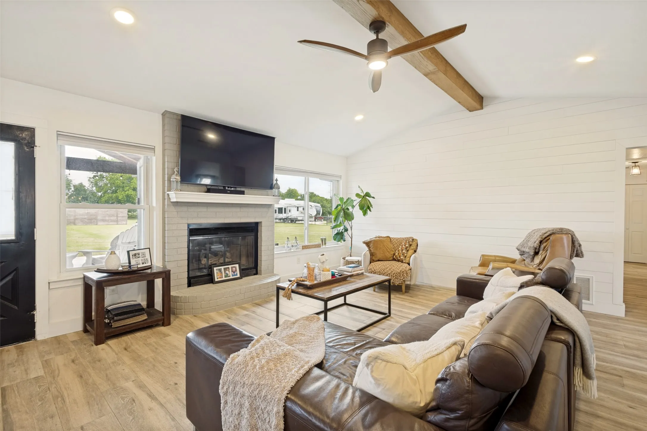 Vaulted ceiling featuring exposed wood beams and a ceiling fan
