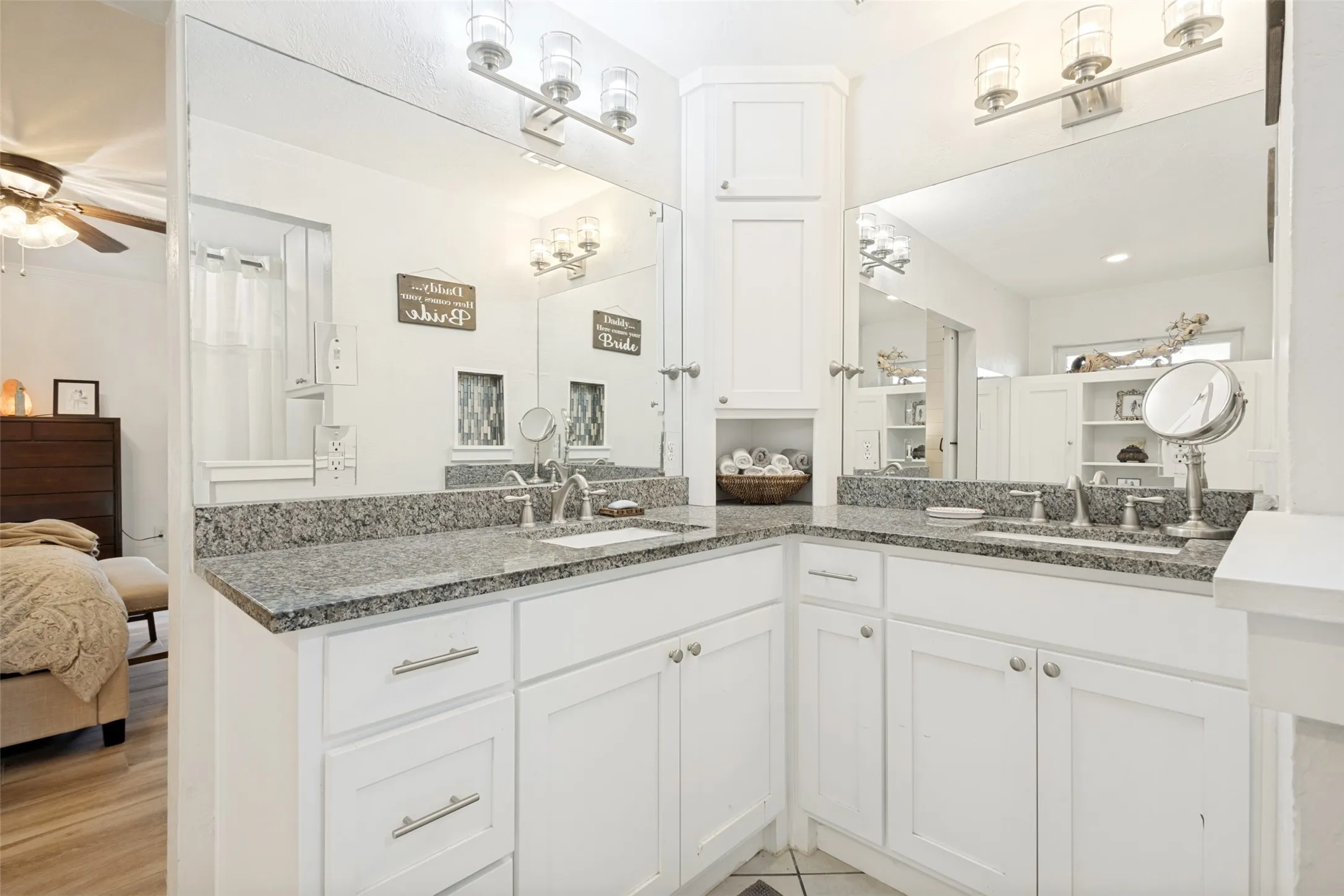 Dual vanity with granite countertops, white cabinetry, undermount sinks, and brushed nickel fixtures