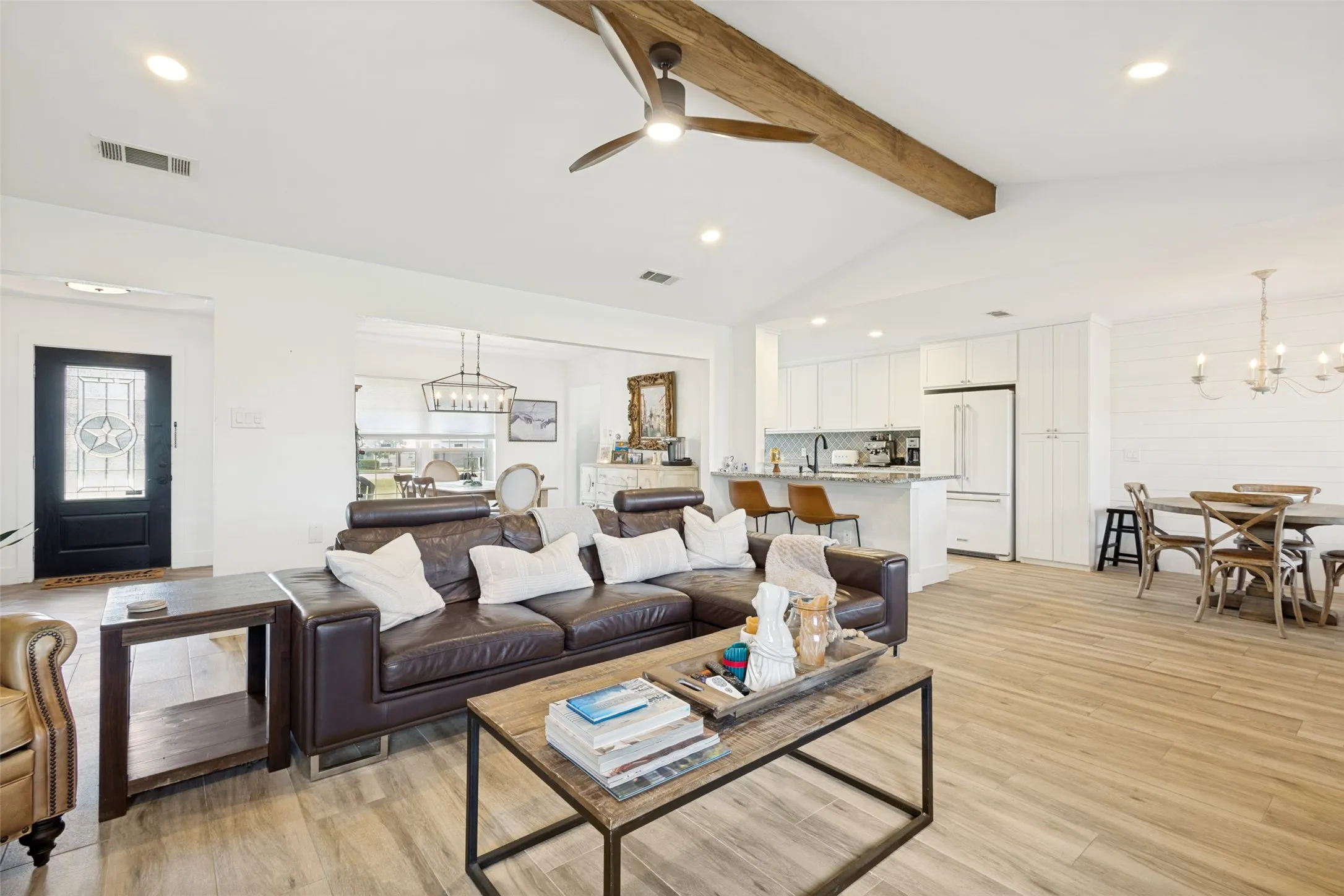 Vaulted ceiling featuring a wood beam and ceiling fan