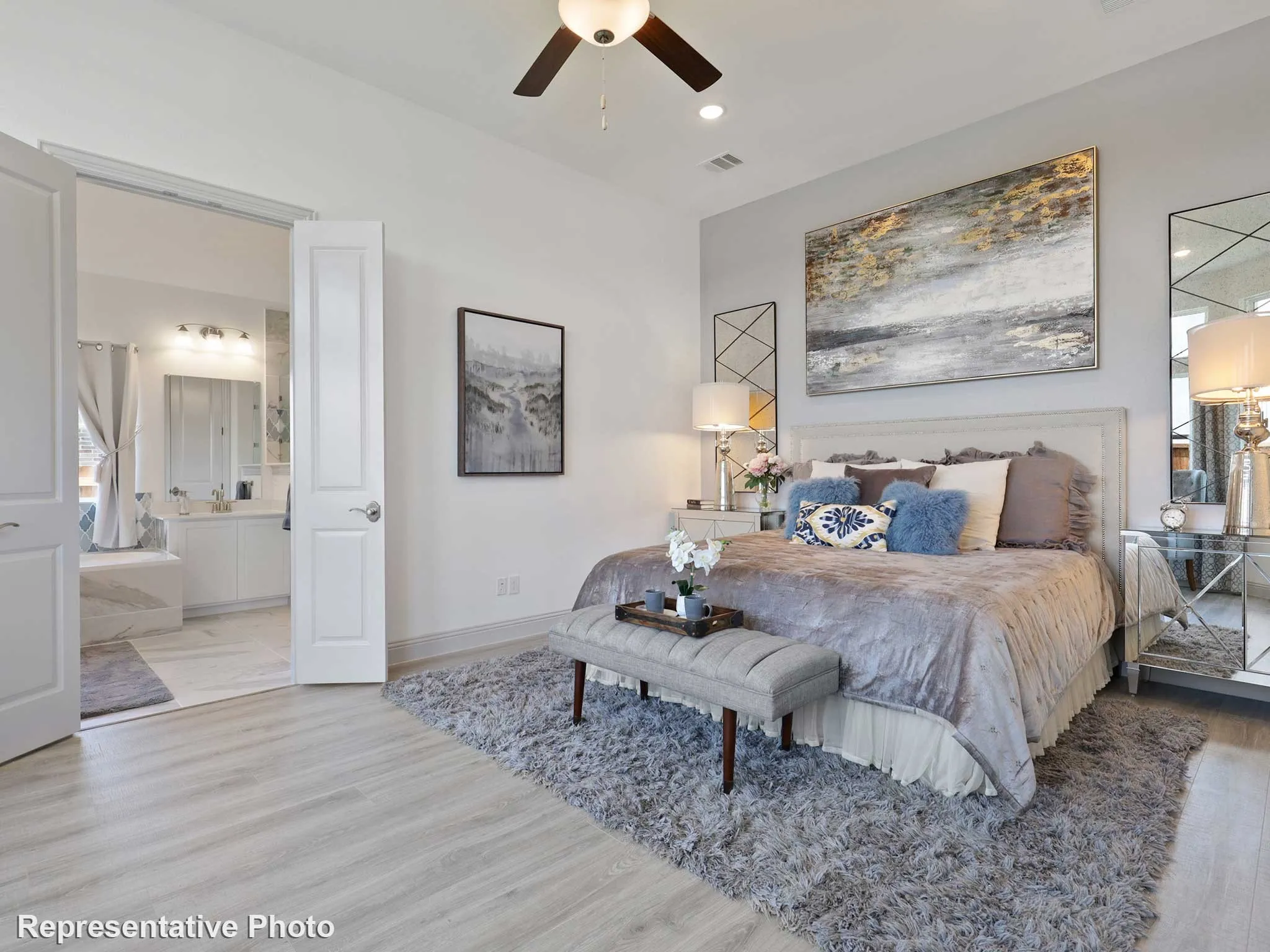 Spacious bedroom with light wood-finish flooring, recessed lighting, and a ceiling fan