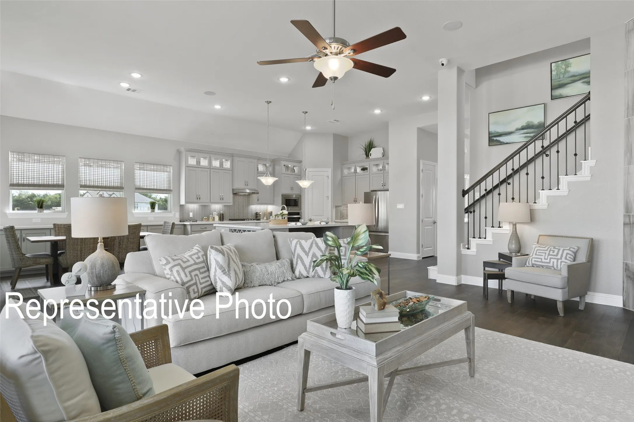 Expansive open-concept living area featuring dark wood-finish flooring and a decorative ceiling fan