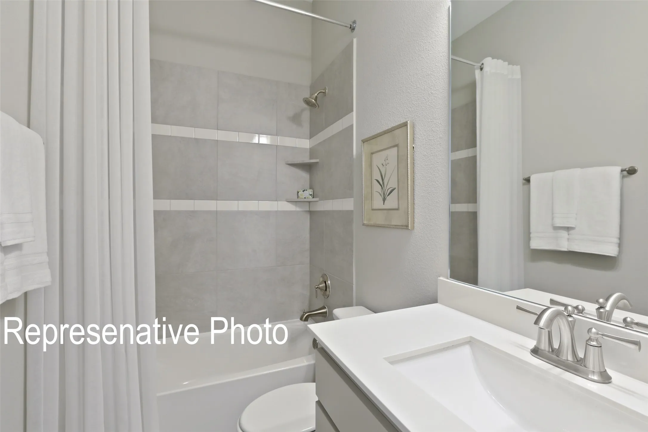 Bathroom featuring a single-sink vanity with white countertop, chrome faucet, and integrated sink basin