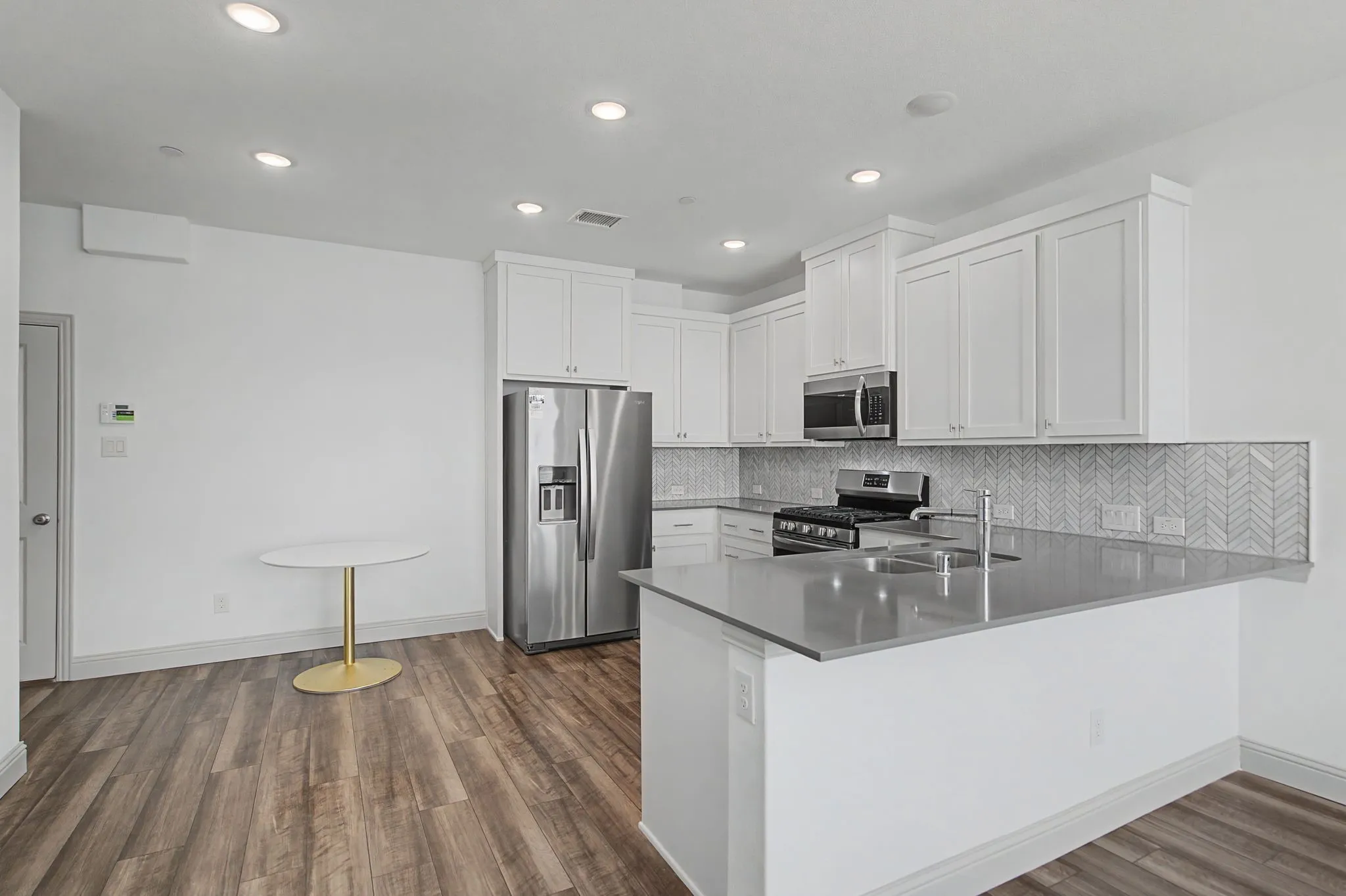 Modern kitchen featuring white cabinetry, stainless steel appliances, and a grey countertop