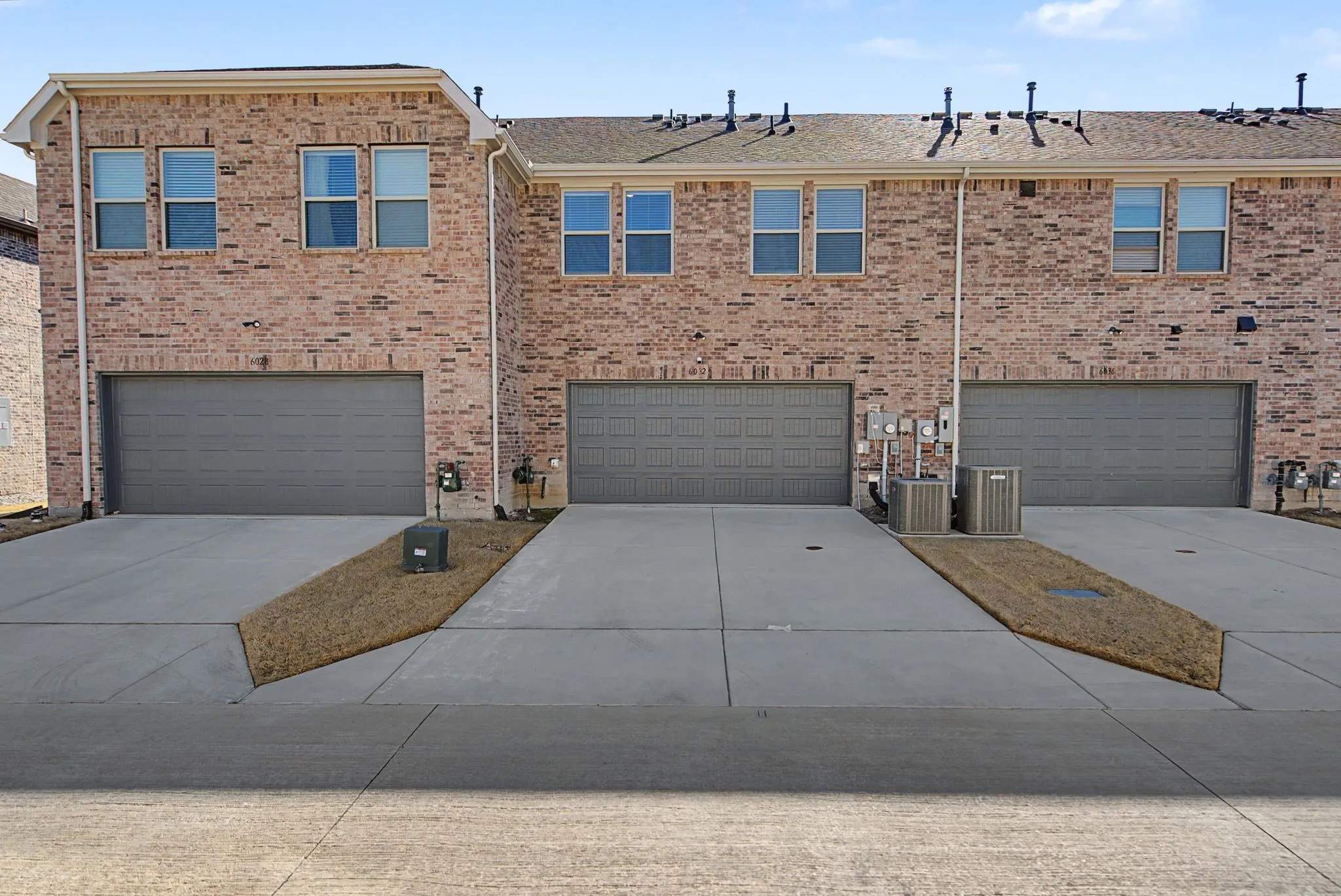 Brick facade townhome with individual garage and dedicated driveway