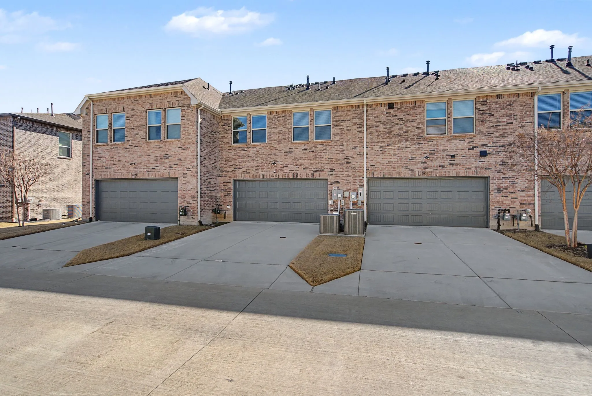 Brick exterior townhome with an attached two-car garage