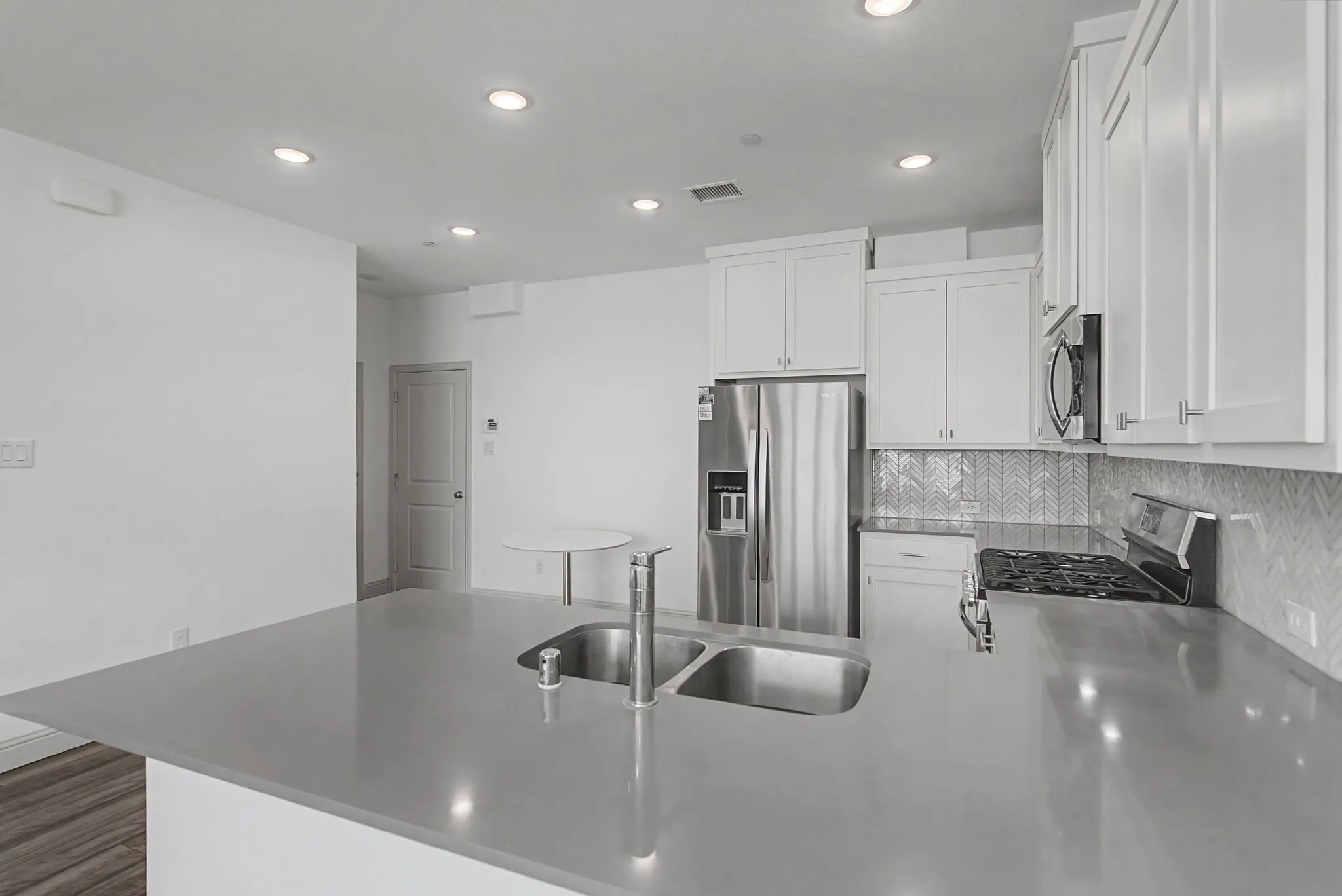 Kitchen island featuring a double basin stainless steel sink and gooseneck faucet