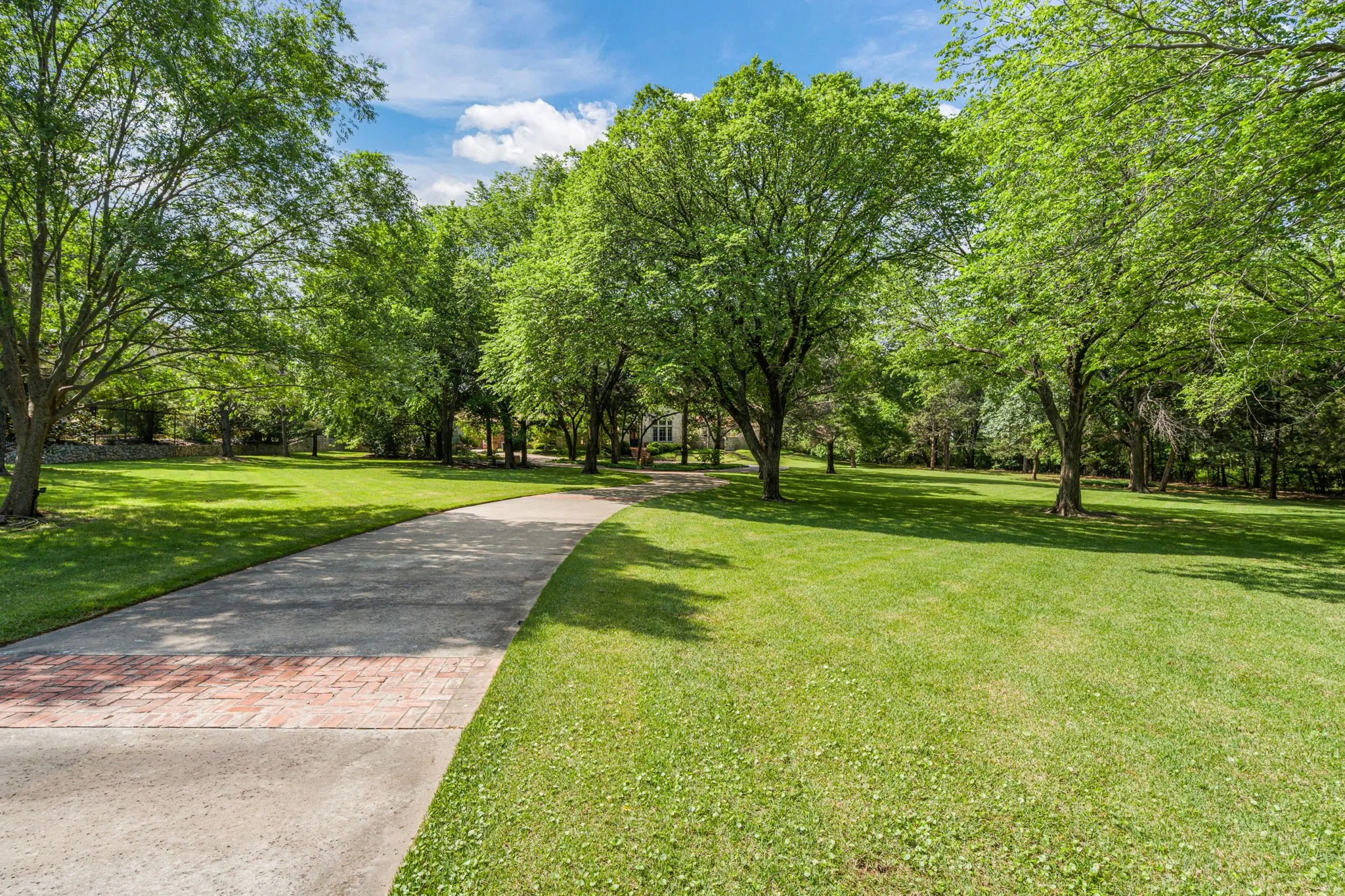 The drive up to the house beckons you past expansive lawns and under the shade of mature trees.